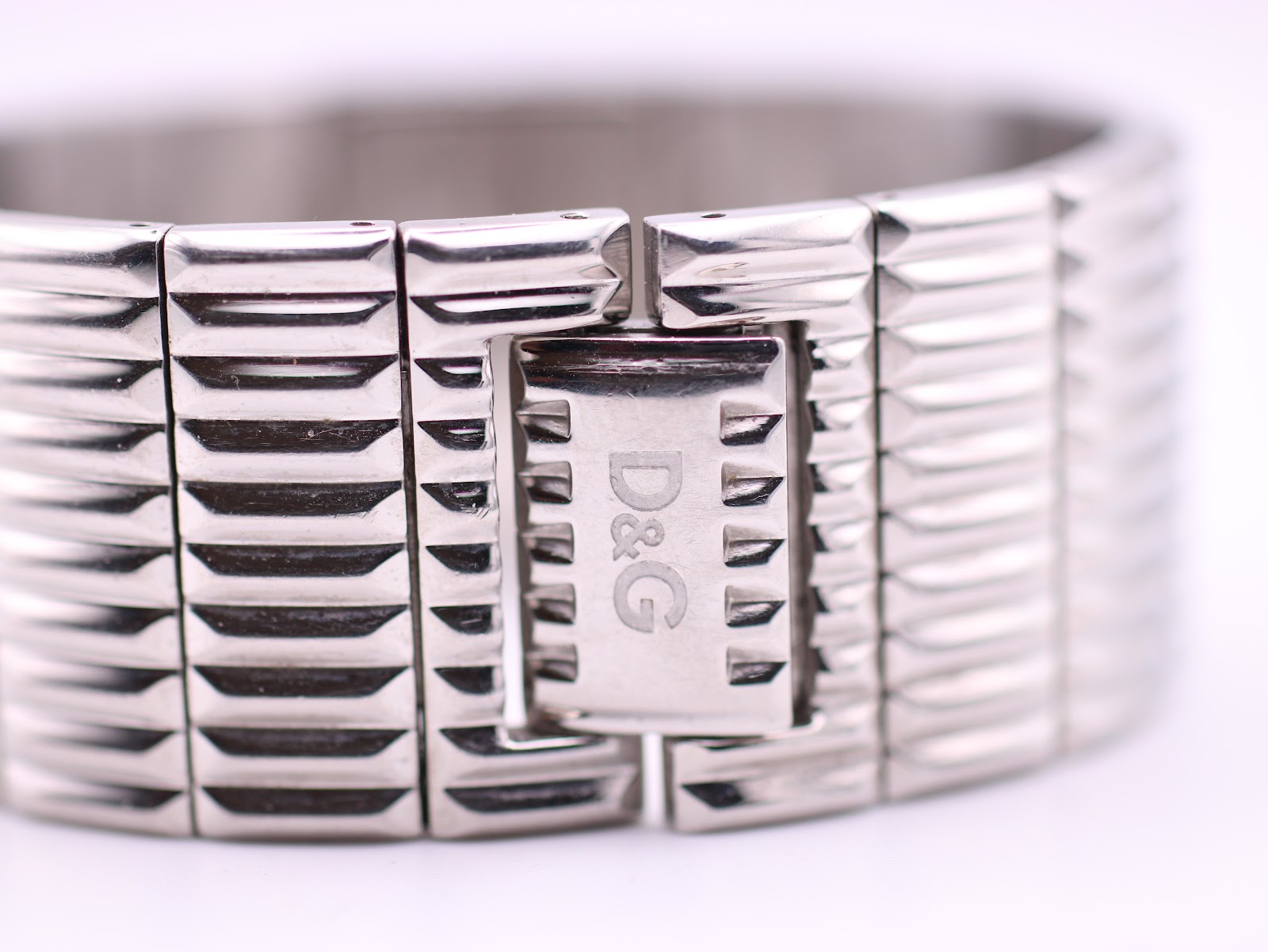 Close-up of the integrated bracelet's hidden deployment clasp, showing the D&G logo.