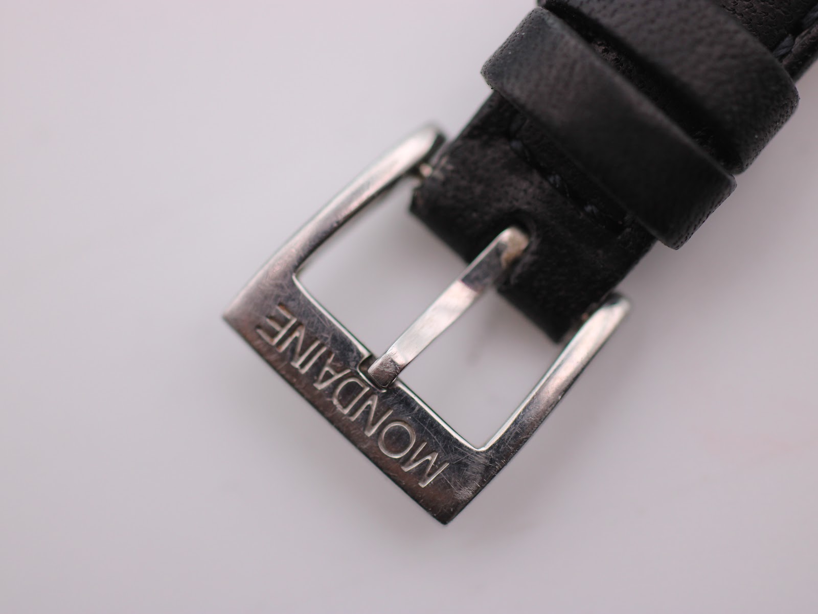 Close-up of the polished silver buckle, clearly showing the 'MONDAINE' engraving.
