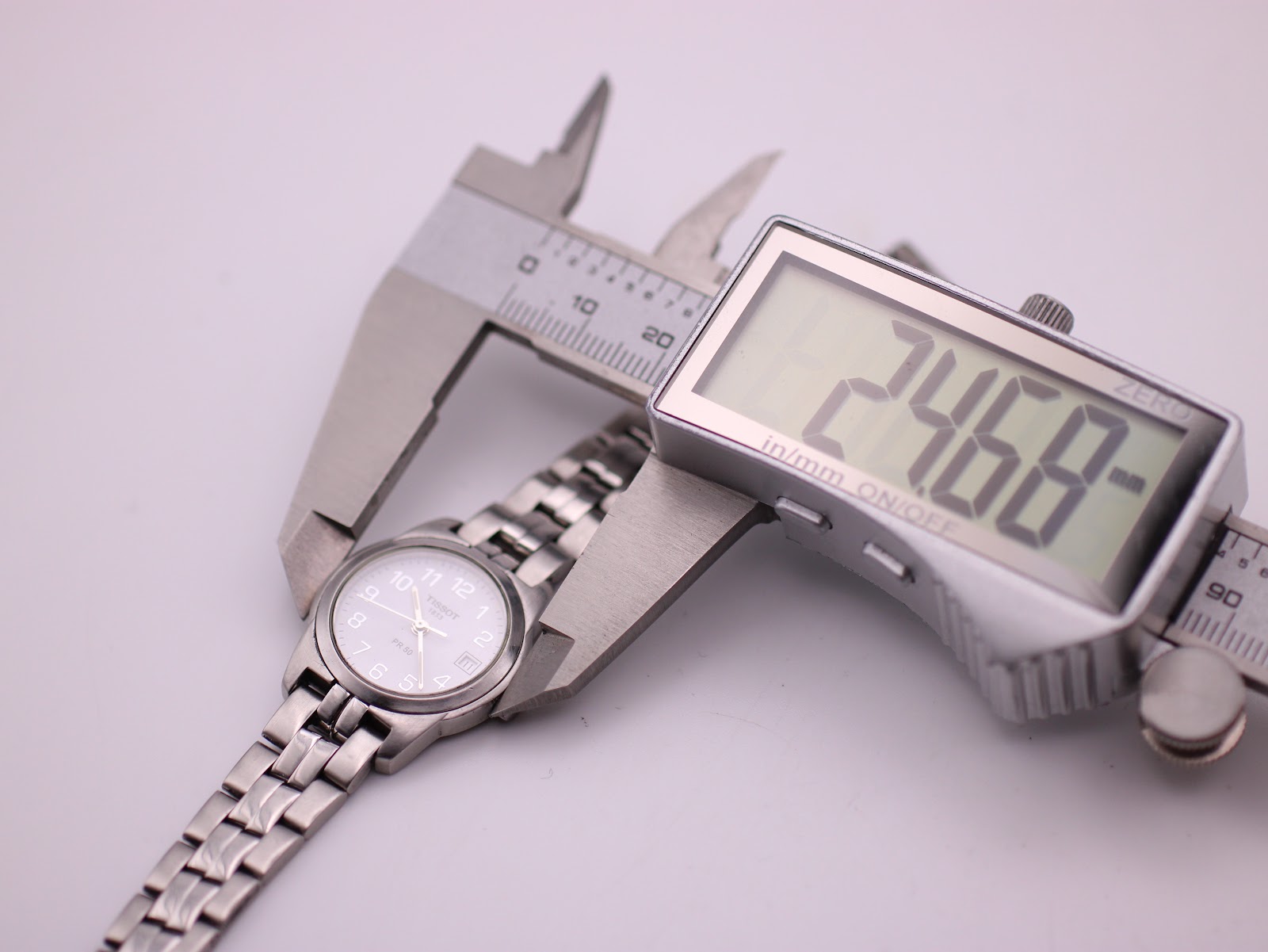 The Tissot PR 50 watch with a digital caliper displaying the case diameter of 24.68mm.