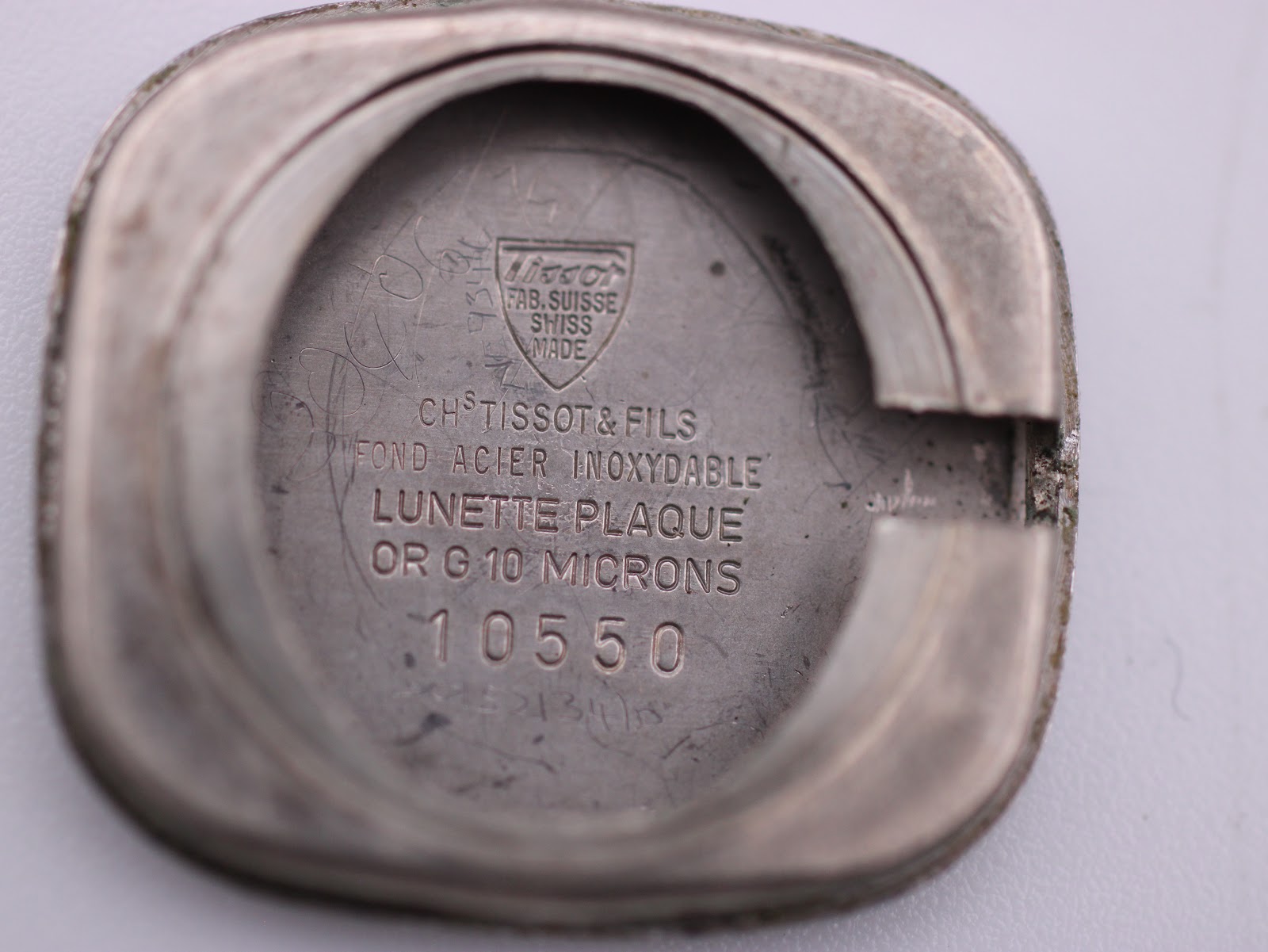Inside view of the Tissot Stylist case back, with engravings 'Tissot FAB. SUISSE SWISS MADE', 'FOND ACIER INOXYDABLE', 'LUNETTE PLAQUE OR G 10 MICRONS', and model number 10550.