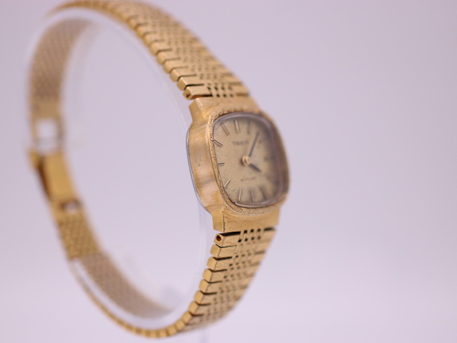Opposite angled side view of the Tissot Stylist, showing the case profile and bracelet links.