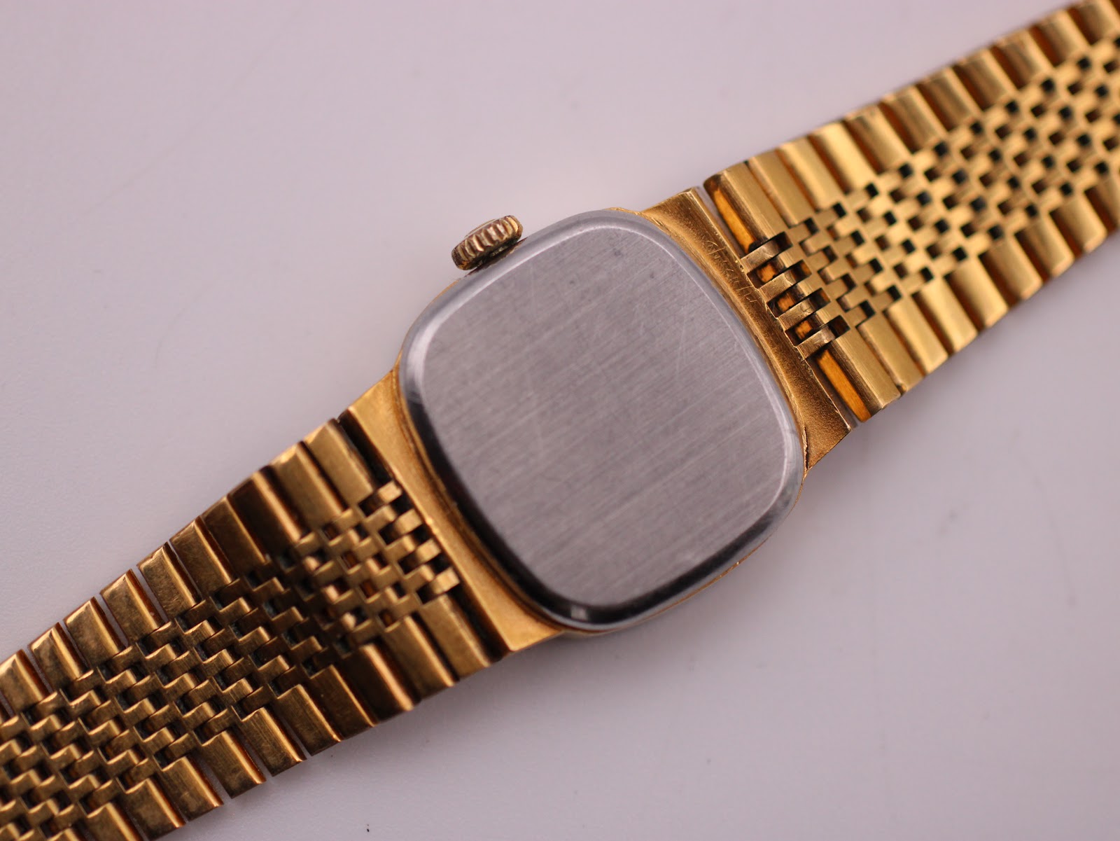 Back view of the Tissot Stylist watch, showing the brushed stainless steel case back and the integrated bracelet.