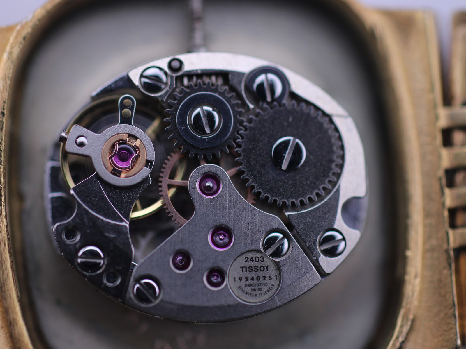 Detailed view of the Tissot 2403 manual wind movement, showing gears, jewels, and serial number 19540251.
