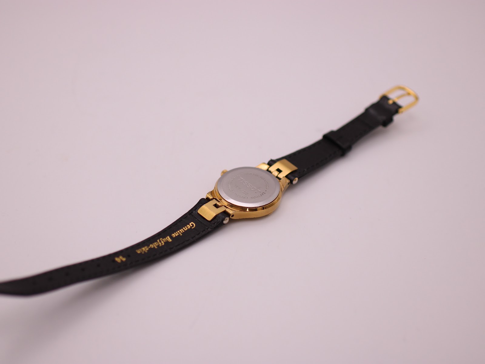 View of the watch back and strap, showing the stainless steel case back and 'Genuine buffalo-skin' text on the strap.
