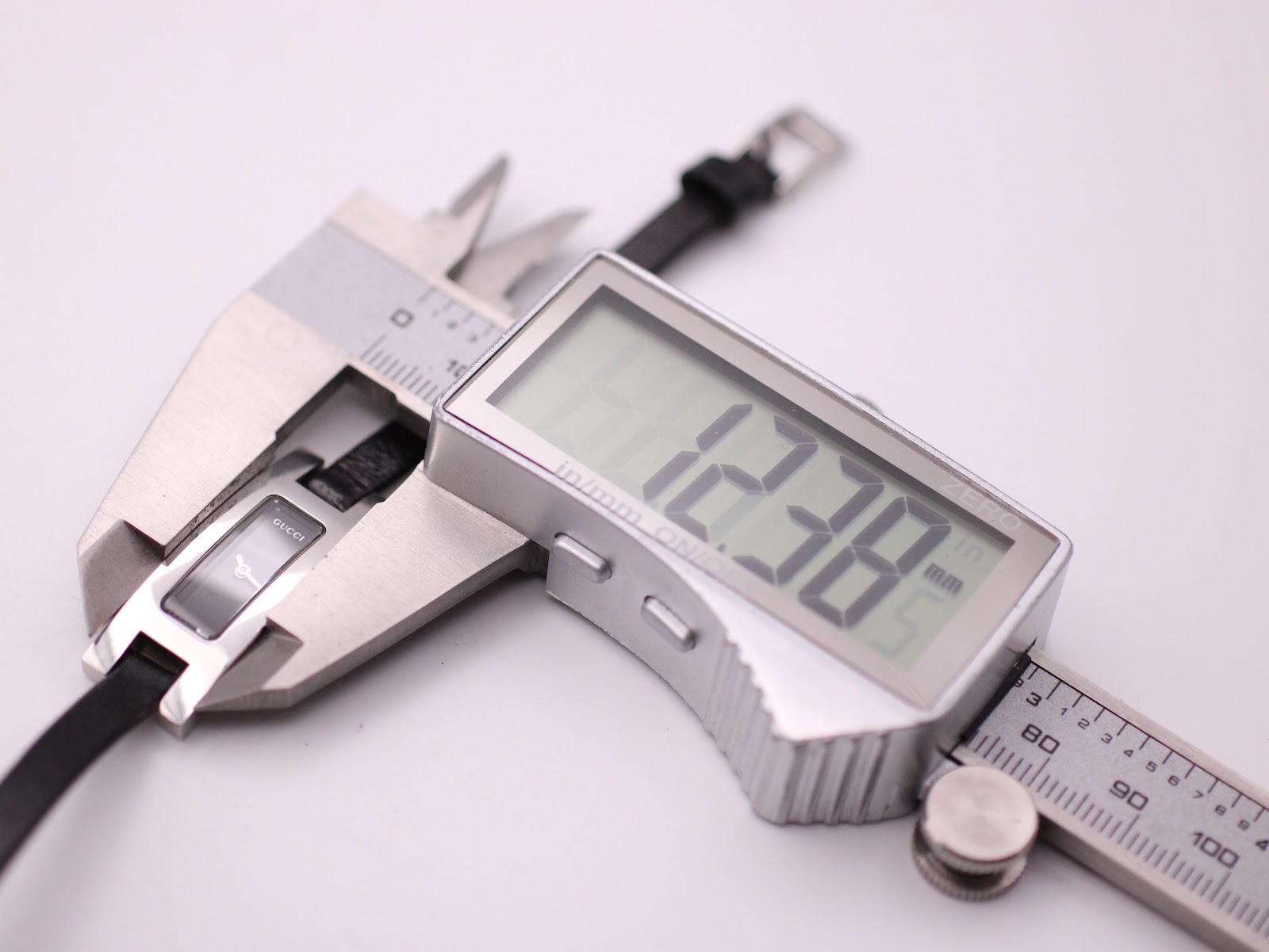 Digital caliper measuring the case width of the Gucci 3900L watch, showing 12.38mm.