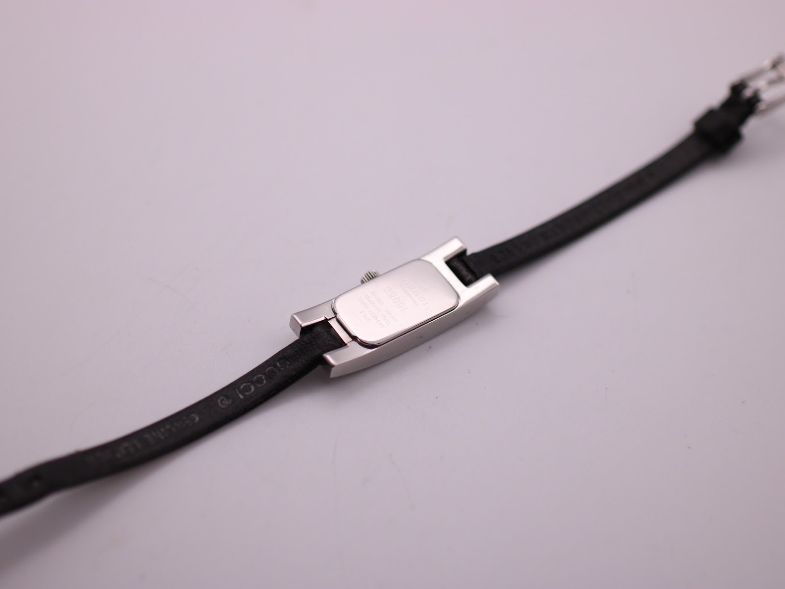 Rear view of the Gucci 3900L watch case back and the black leather strap.