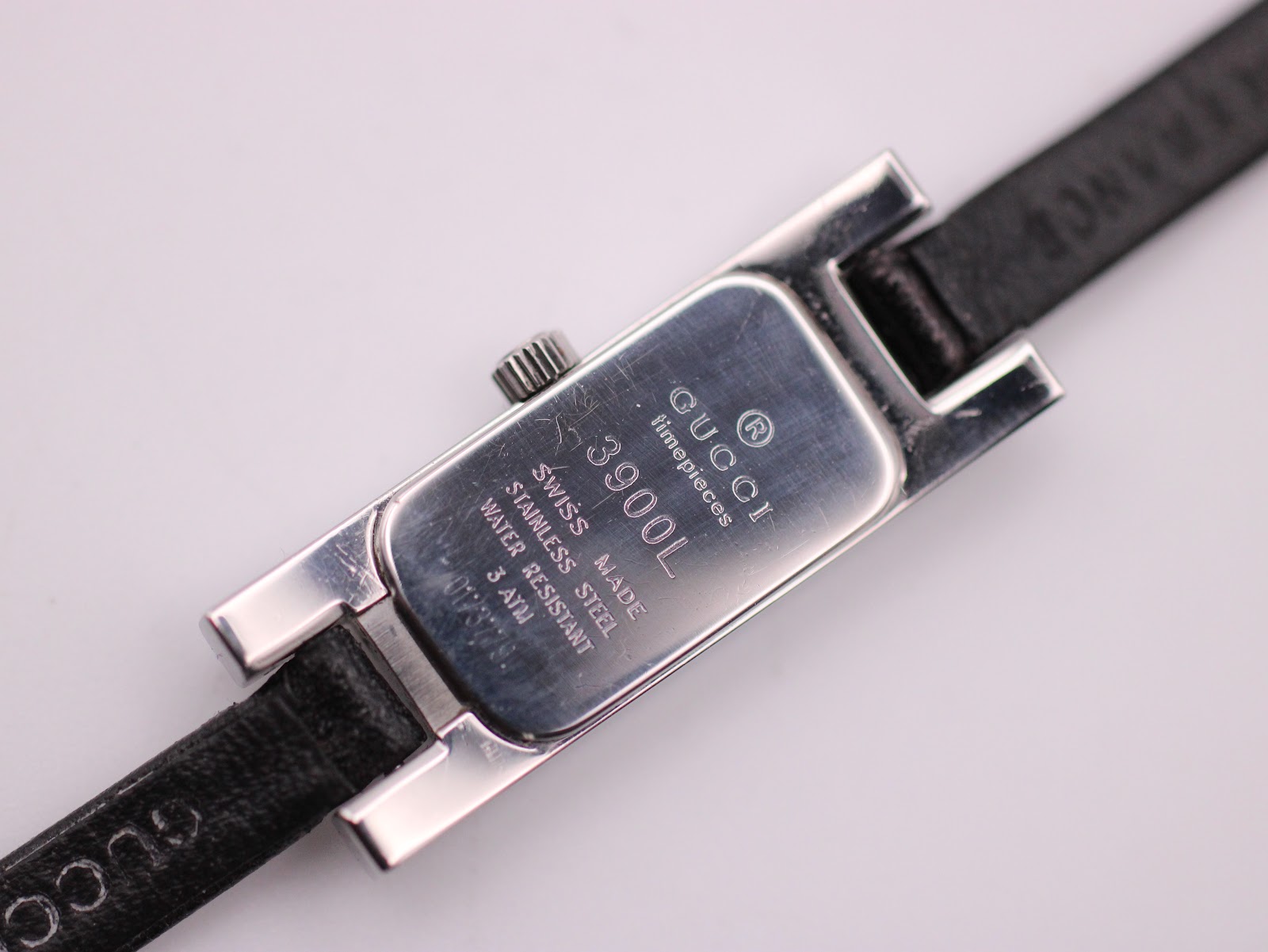 Close-up of the Gucci 3900L stainless steel case back showing model, serial, and water resistance engravings.