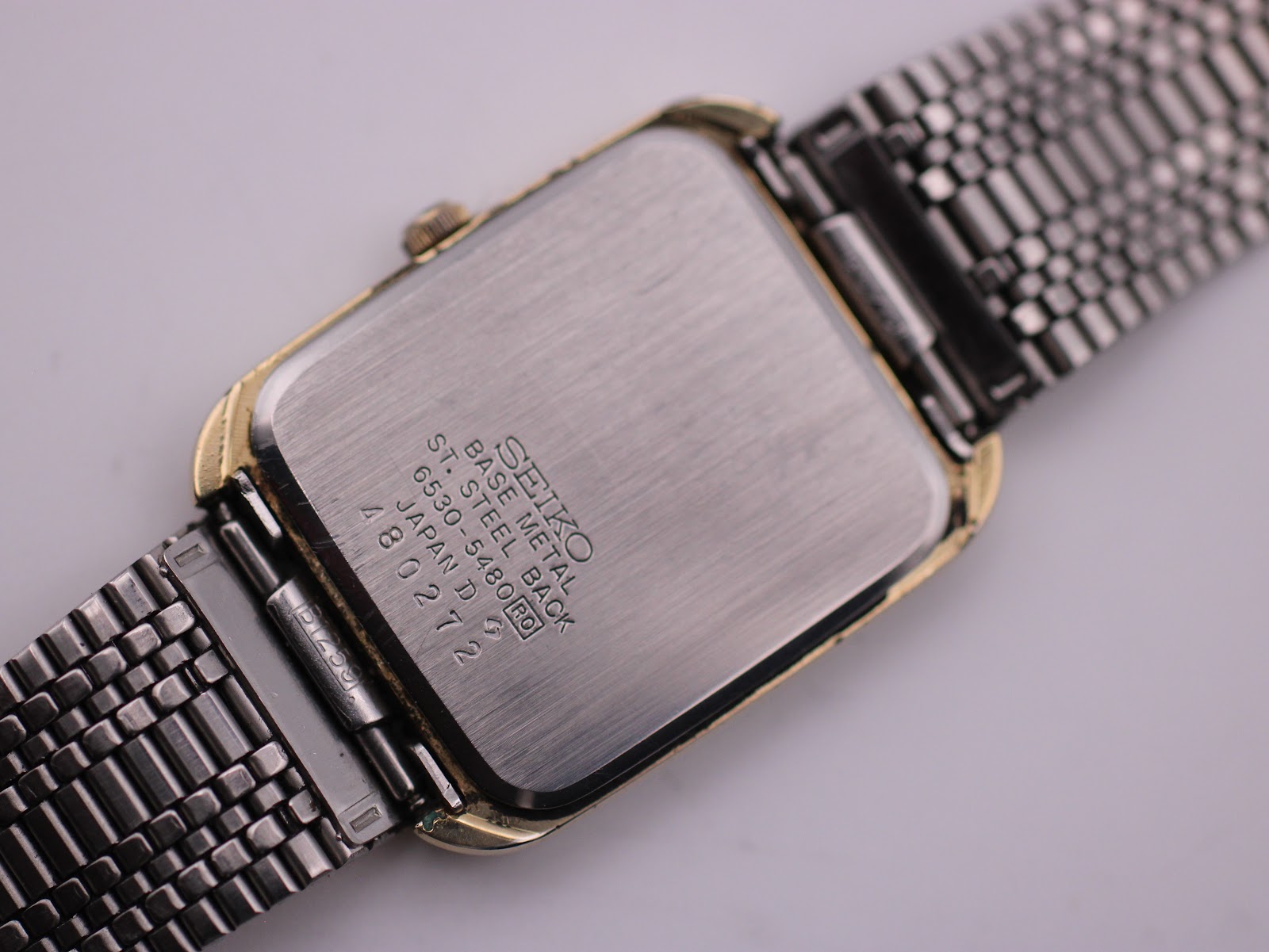 Detailed close-up of the stainless steel case back engravings: 'SEIKO BASE METAL BEZEL ST. STEEL BACK 6530-5480 R0 JAPAN D 480272'.