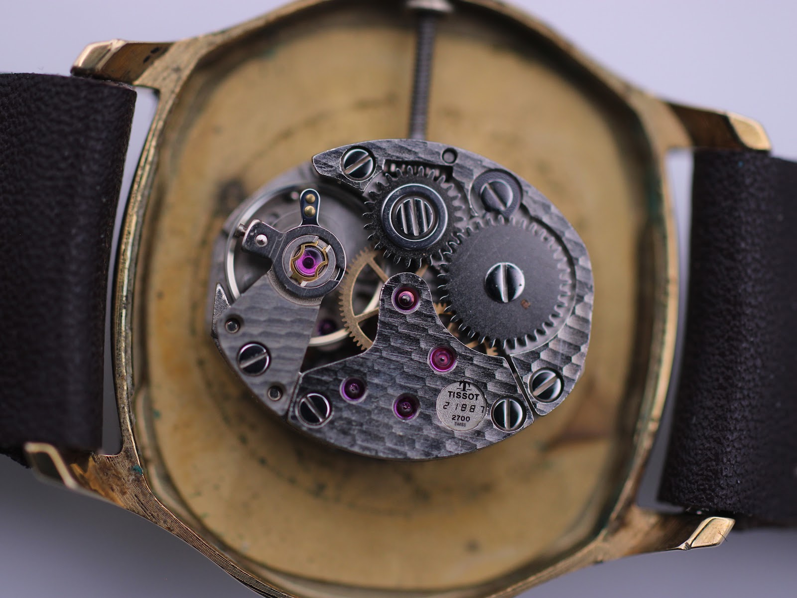 Macro view of the Tissot manual wind movement, showing gears and jewels.