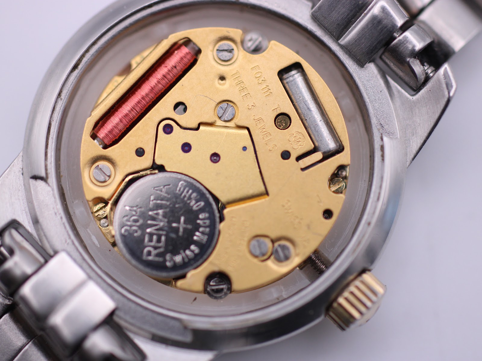 Macro shot of the Swiss quartz movement inside the watch case with a new Renata battery fitted.