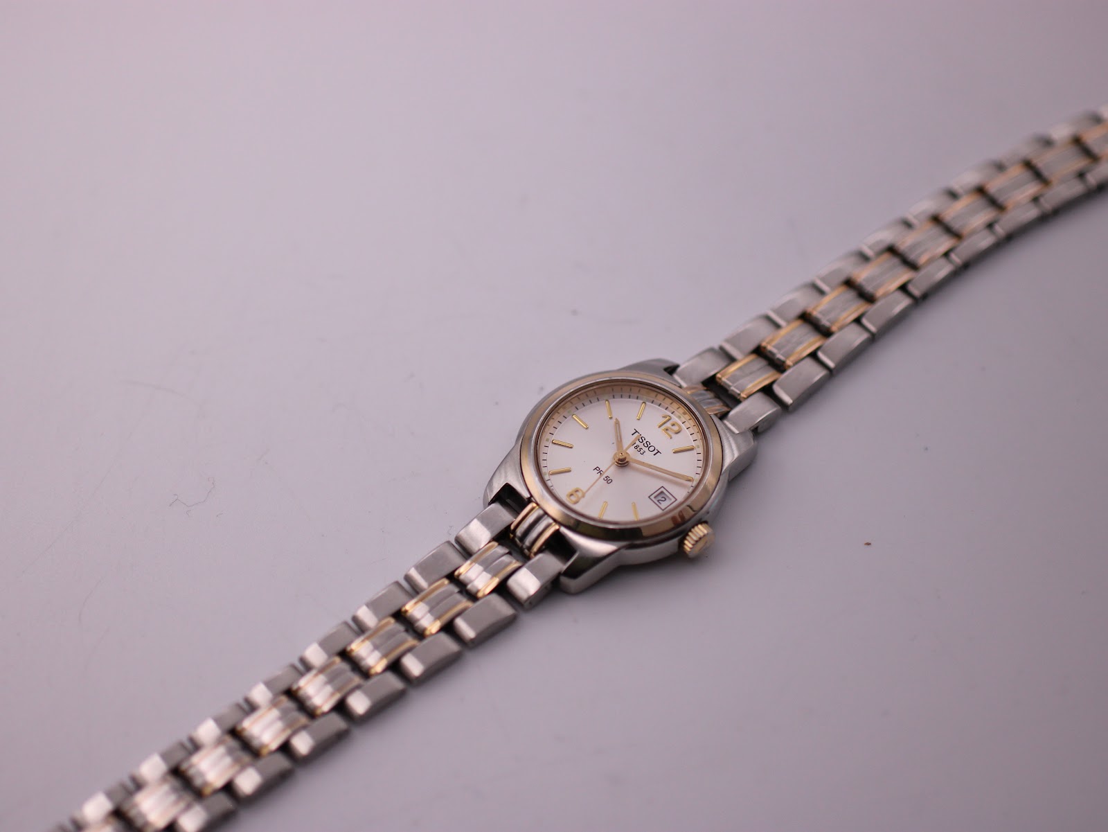 Angled top view of the Tissot PR 50 watch, showing the full two-tone bracelet.