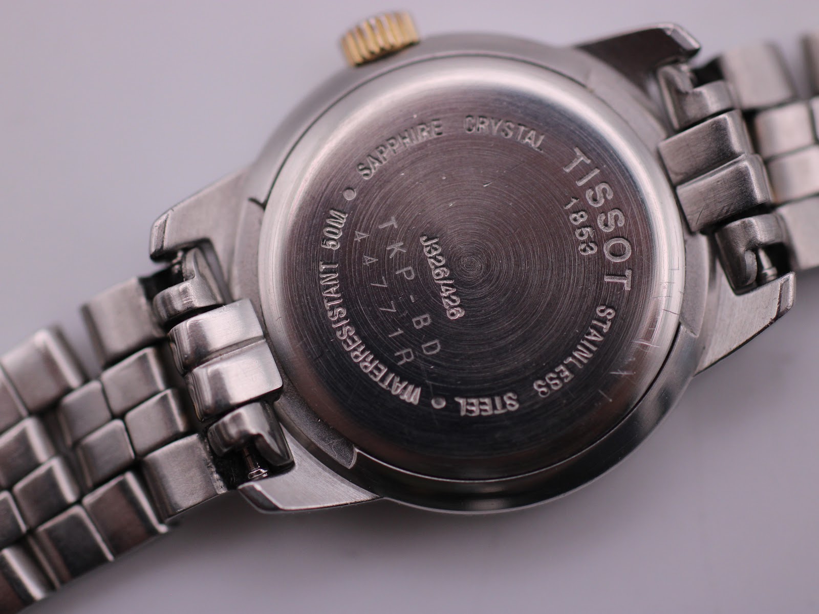 Close-up of the stainless steel case back, showing model number J326/426, "Sapphire Crystal", "Waterresistant 50m", and "Swiss Made".