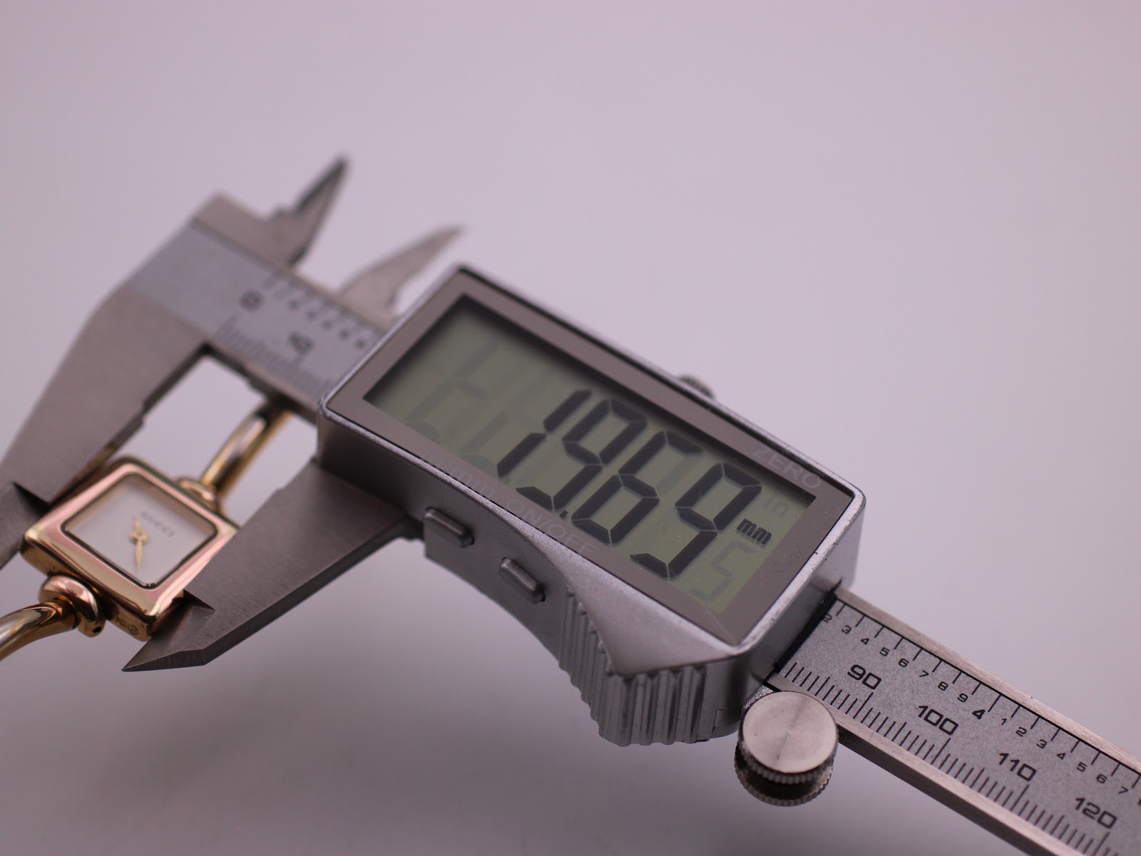Digital caliper measuring the case diameter of the Gucci 1900L, displaying a precise measurement of 19.69mm.