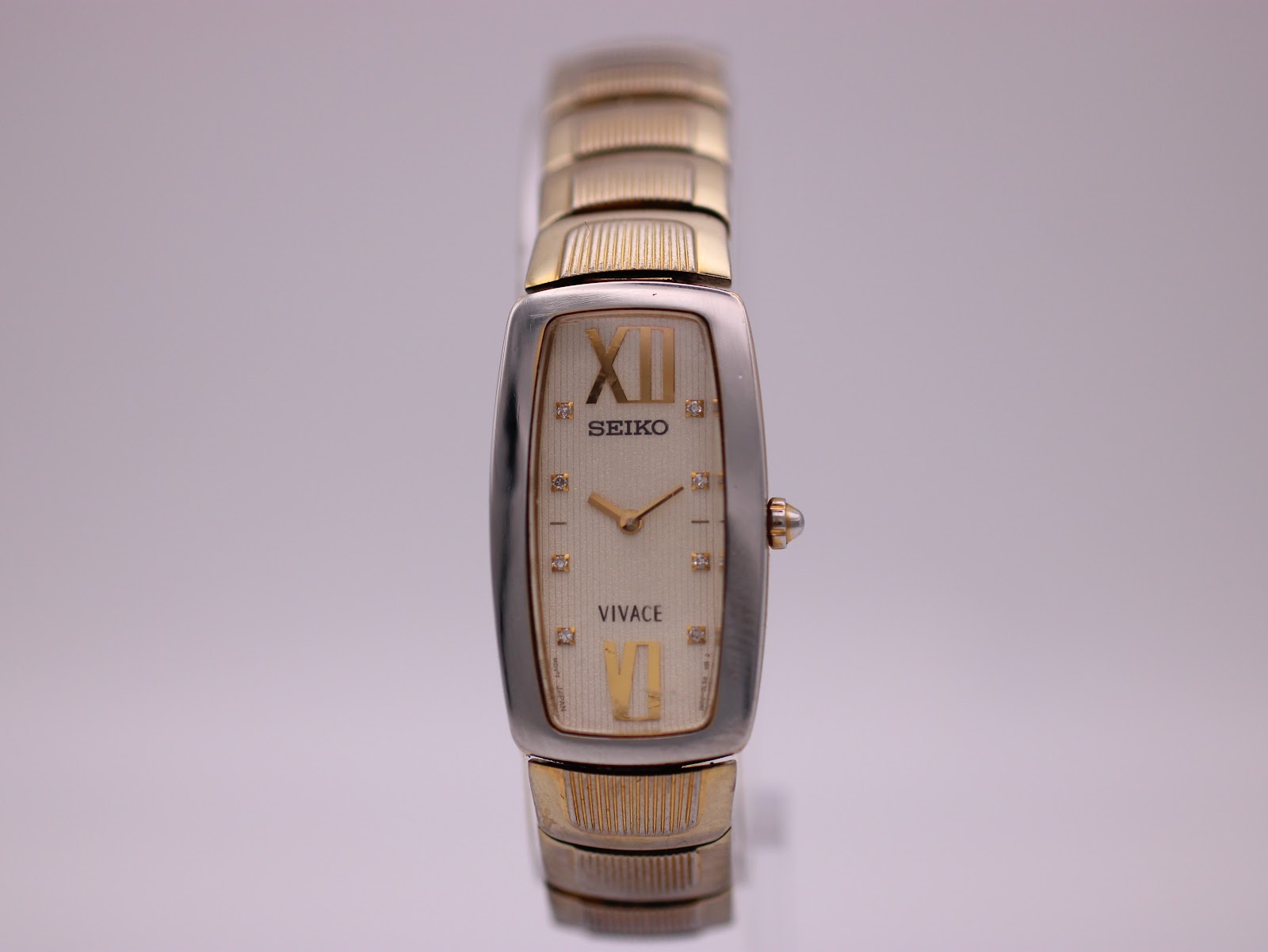 Front angled view of a Seiko Vivace two-tone rectangular ladies watch with a cream dial and gold-tone roman numerals.