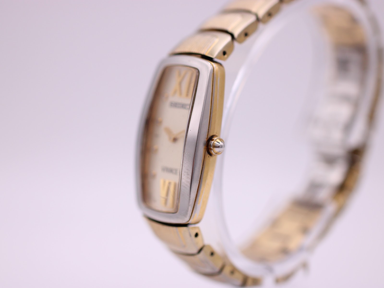 Close-up straight-on front view of the Seiko Vivace cream dial, showing the textured centre, gold-tone roman numerals (XII, VI) and crystal hour markers.