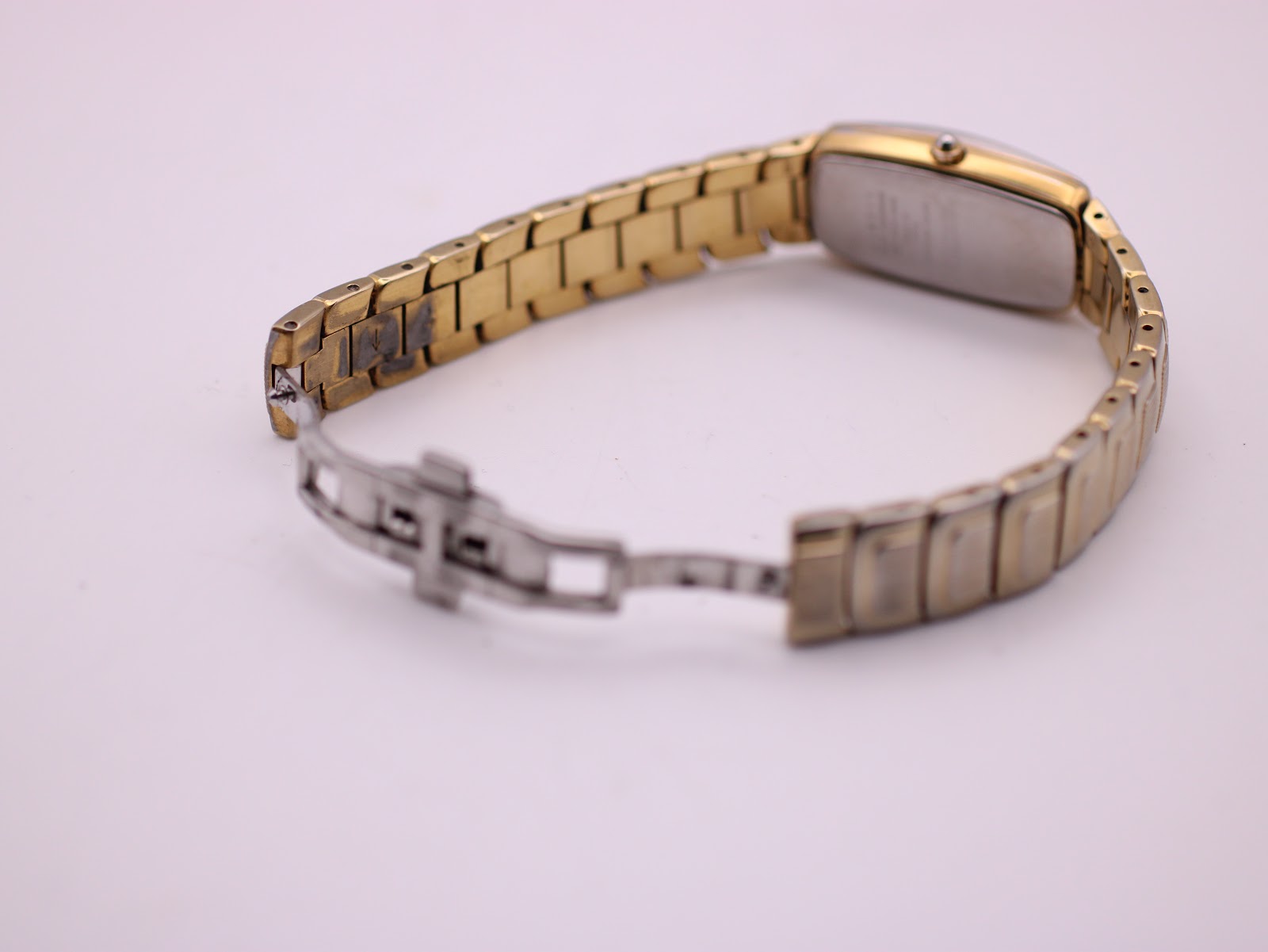 View of the watch with the two-tone steel bracelet unclasped, showing the butterfly clasp mechanism.