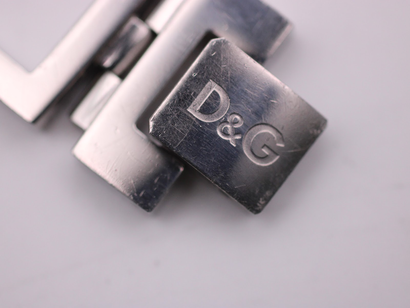 Close-up of the deployant clasp on the D&G Time watch bracelet, engraved with the D&G logo.