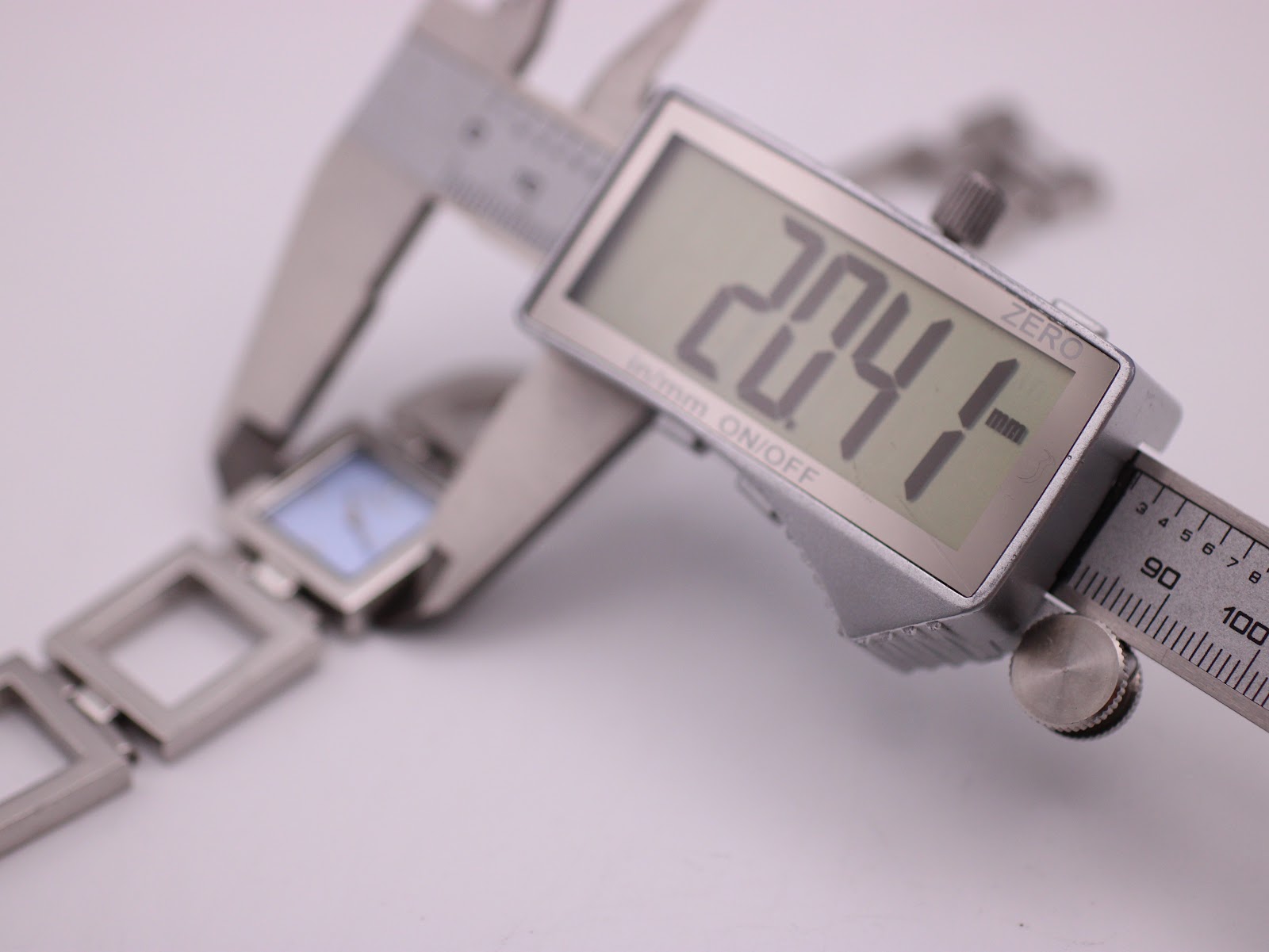 Digital caliper measuring the case diameter of the D&G watch, displaying 20.4 mm.