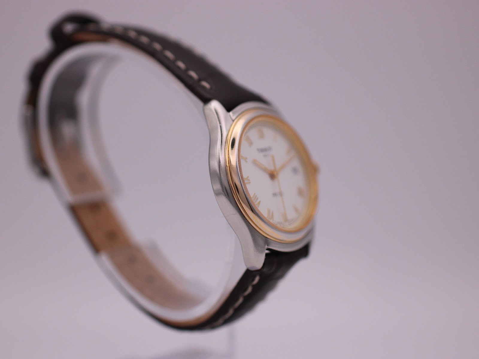 Left side view of the Tissot PR 50 watch on a display stand, showing the curved case profile.