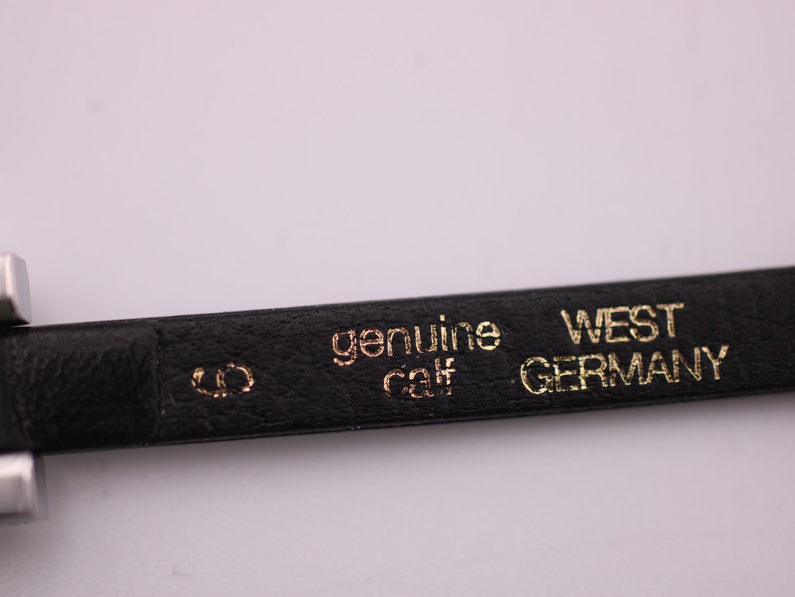 Close-up of the black leather strap's interior, showing "genuine calf WEST GERMANY" markings.