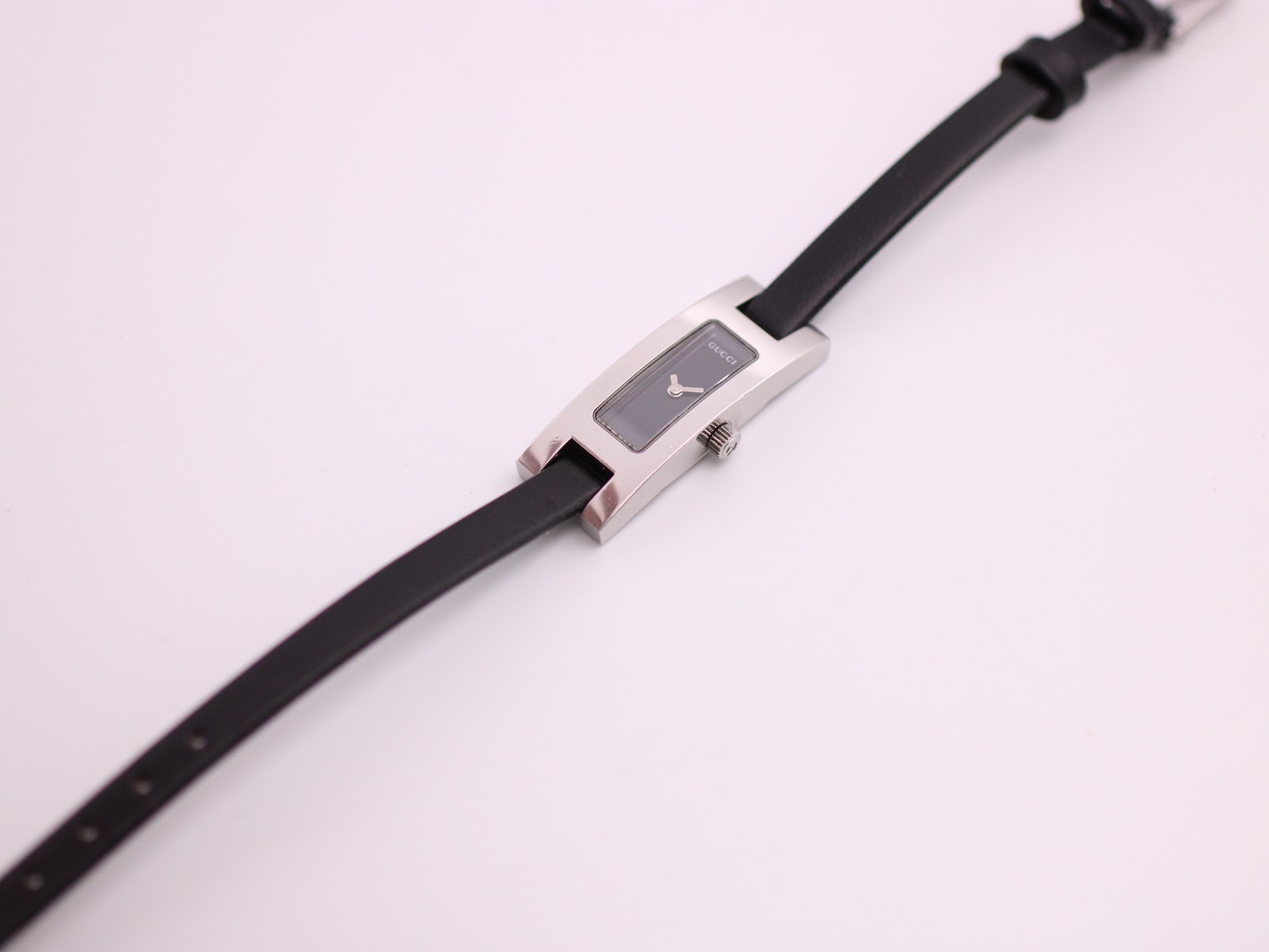 Overhead view of the Gucci 3900L watch laid flat, displaying the entire black leather strap.