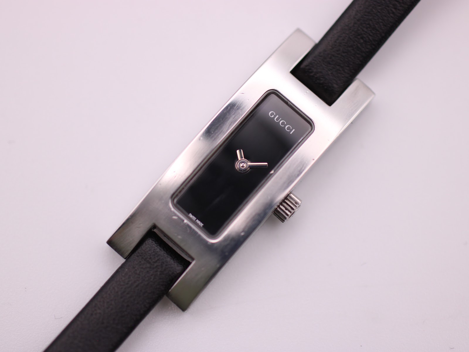 Close-up front view of the Gucci 3900L dial, revealing the minimalist black face and "SWISS MADE" text.