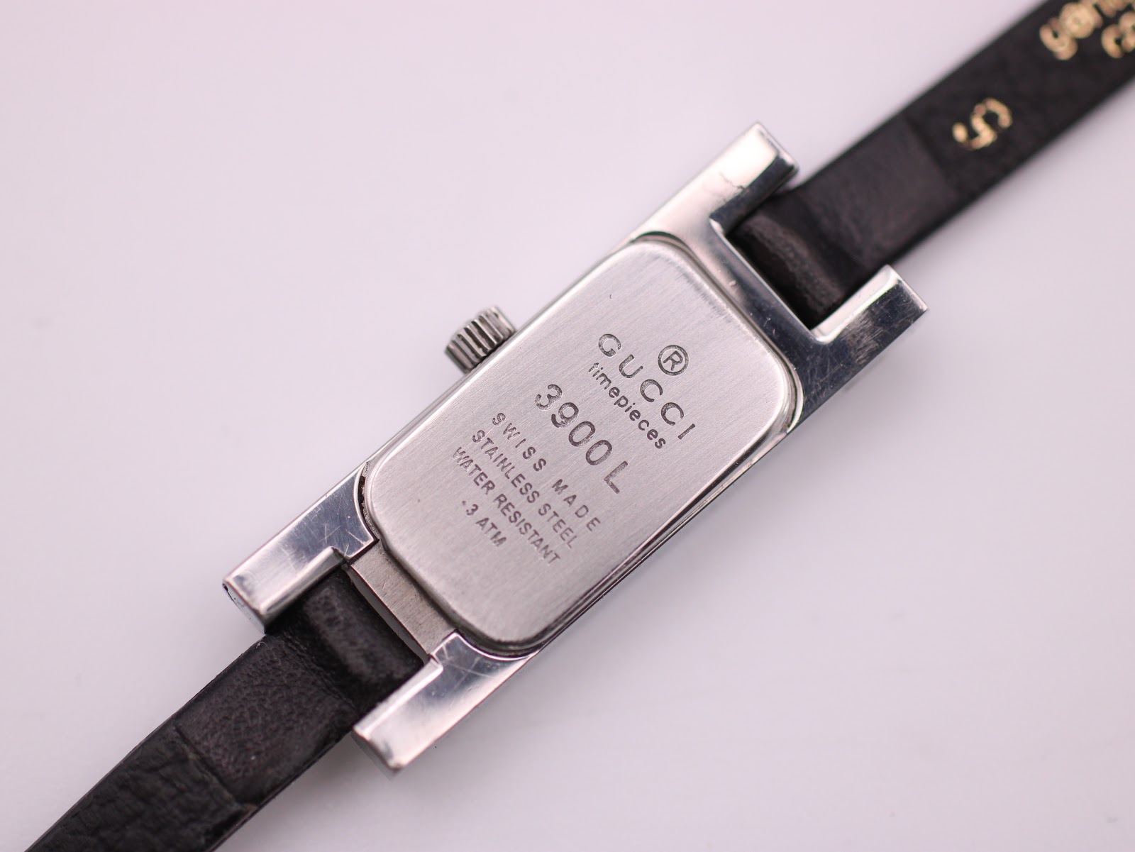 Close-up of the Gucci 3900L case back engraving, showing model number, material, and water resistance.