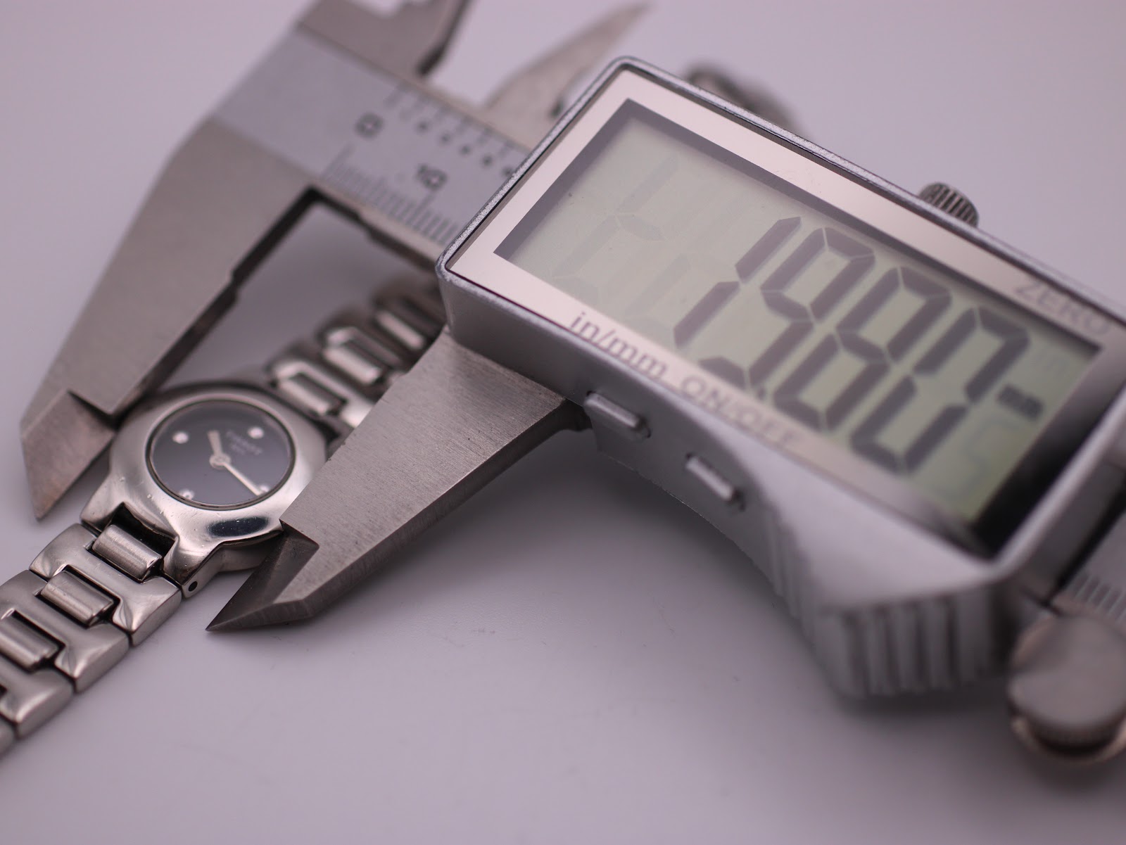 Close-up of a digital caliper measuring the Tissot watch case diameter, displaying 19.88mm.