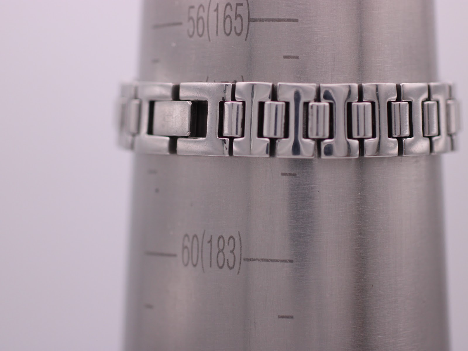 Close-up of the Tissot watch bracelet on a wrist sizing gauge, indicating a wrist circumference of 165mm.