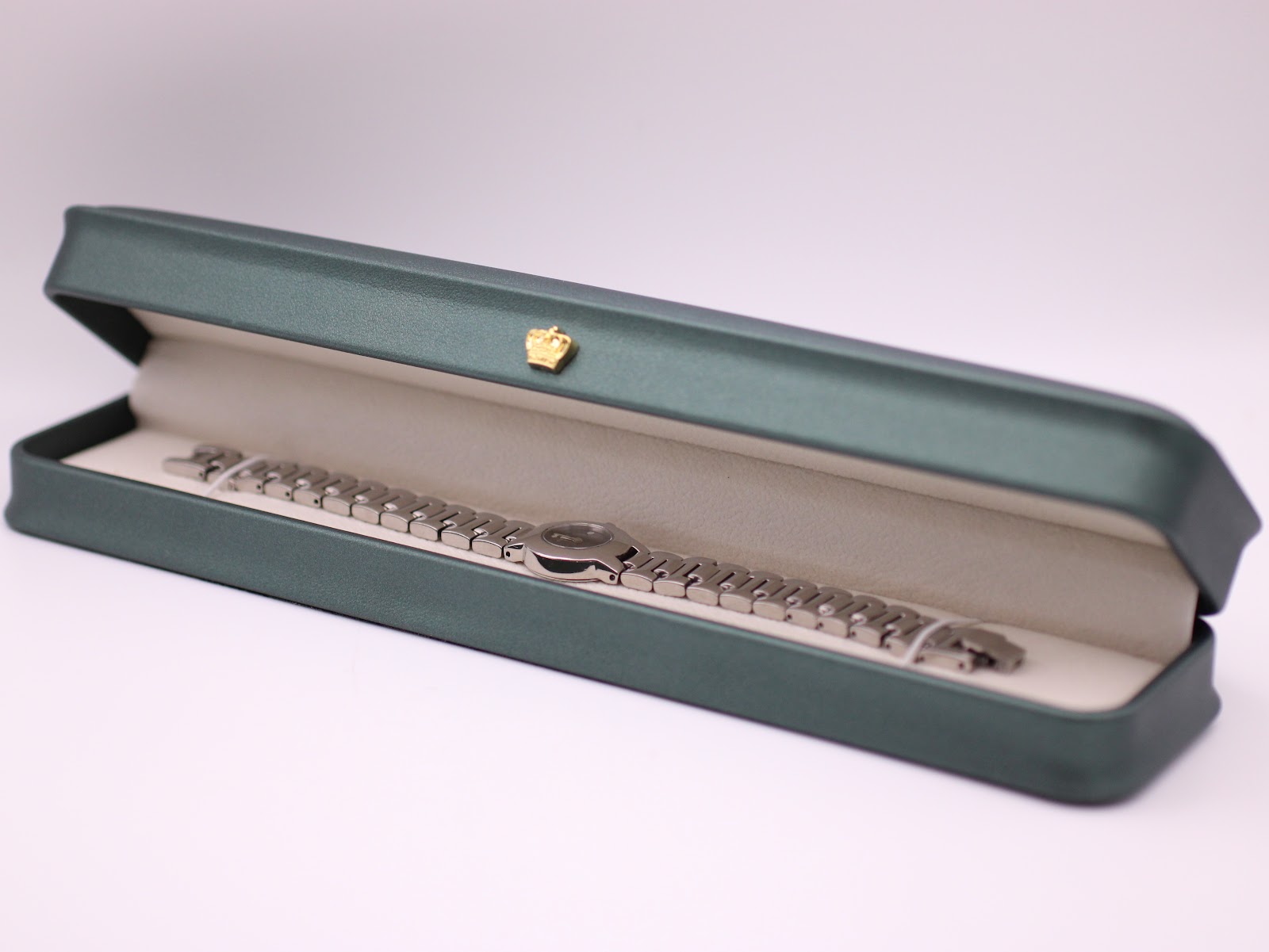 The Tissot watch displayed neatly inside a generic green presentation box (studio prop).