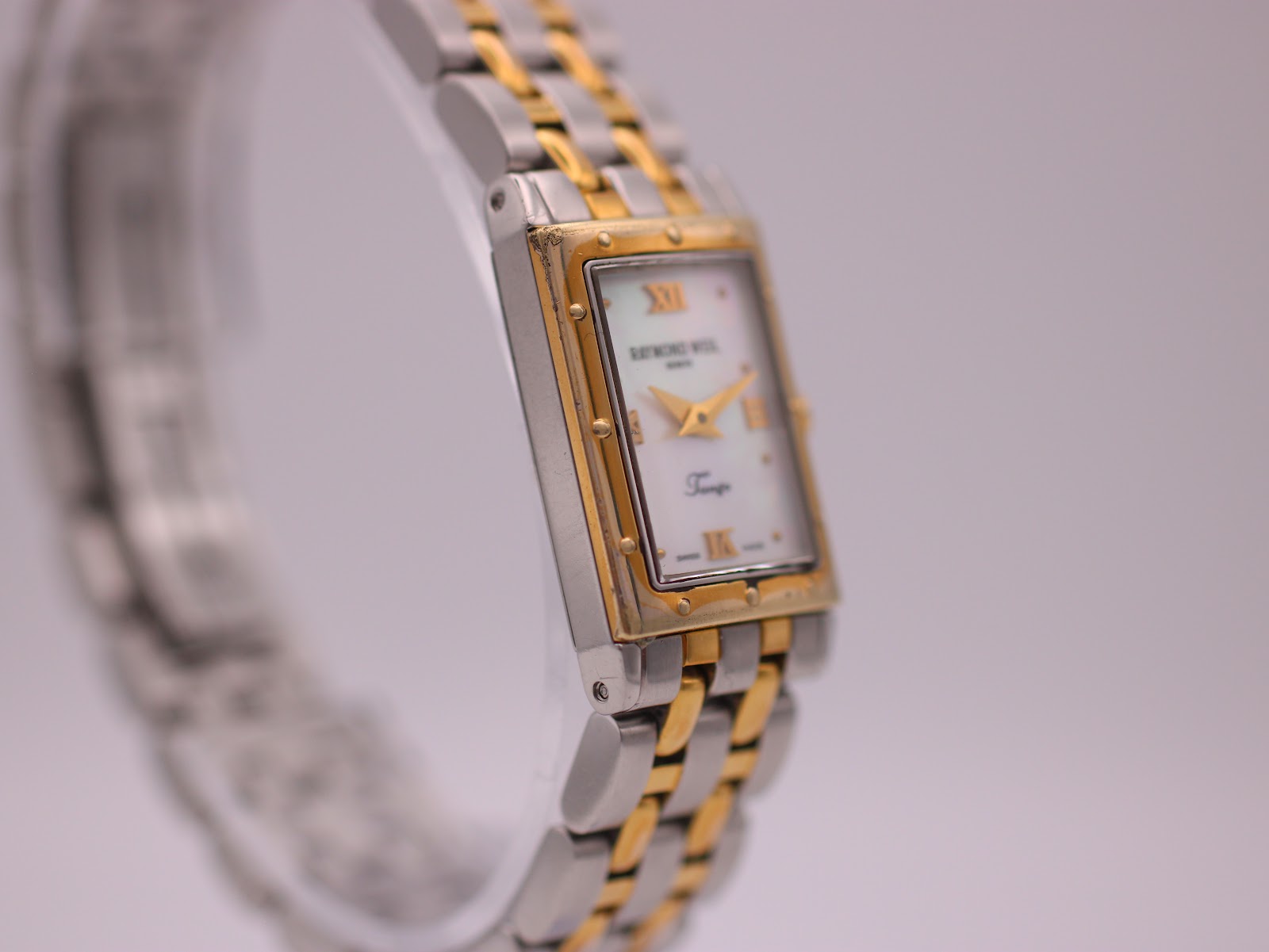 Another angled side view of the watch, showing the profile of the two-tone case and bracelet links.