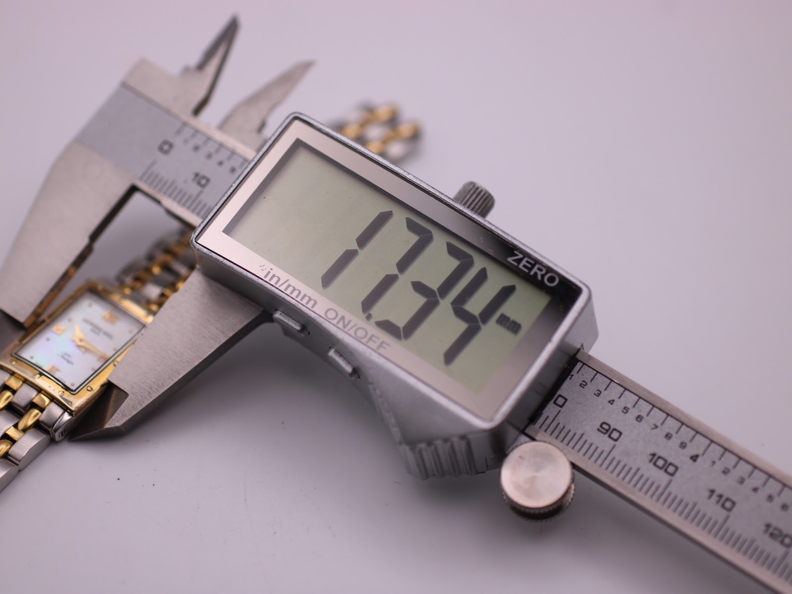 Digital caliper measuring the case width of the Raymond Weil Tango, displaying a precise measurement of 17.34mm.