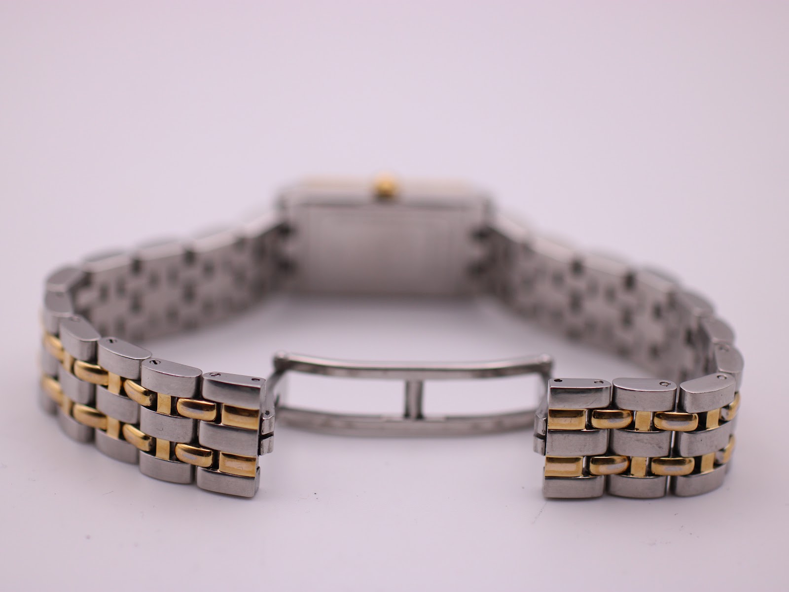 Close-up of the watch's two-tone bracelet with the hidden butterfly clasp open, ready for fastening.