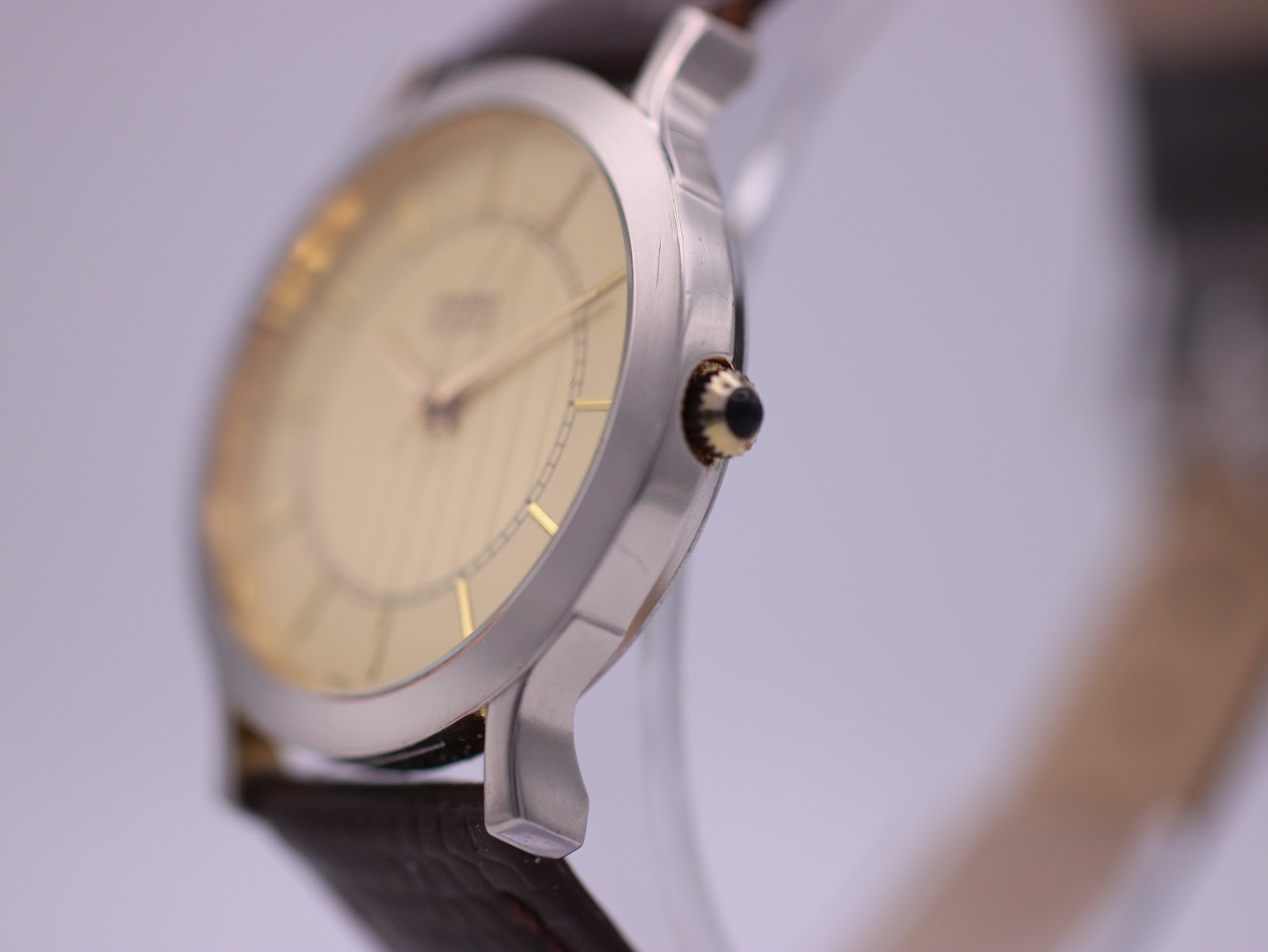 Angled side view of the Seiko watch case and crown, showing the slim profile and gold-tone accents.