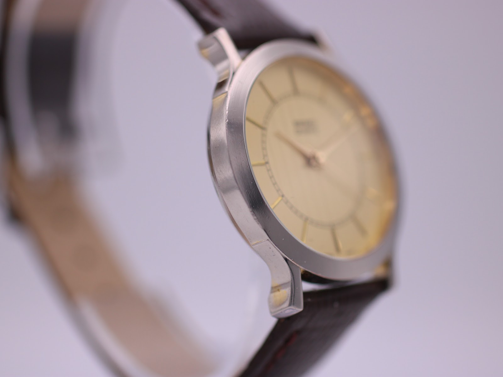 Another angled side view of the watch, highlighting the brushed finish on the silver-tone case.
