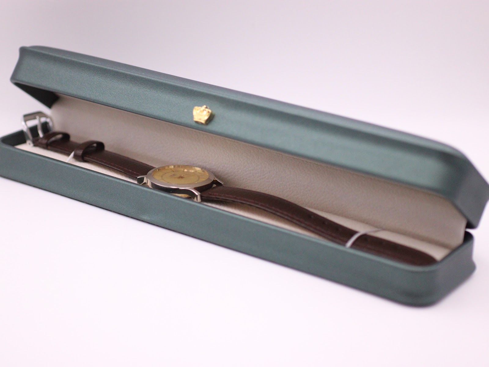 The Seiko watch presented in a generic dark green leatherette display box with a small gold crown emblem.