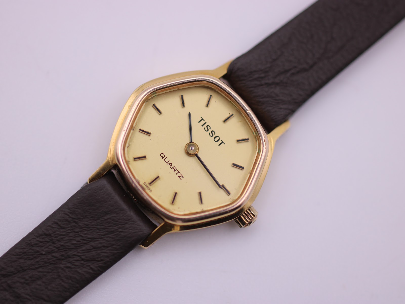 Close-up front view of the Tissot dial, showing 'TISSOT', 'QUARTZ', baton indices, and black hands.