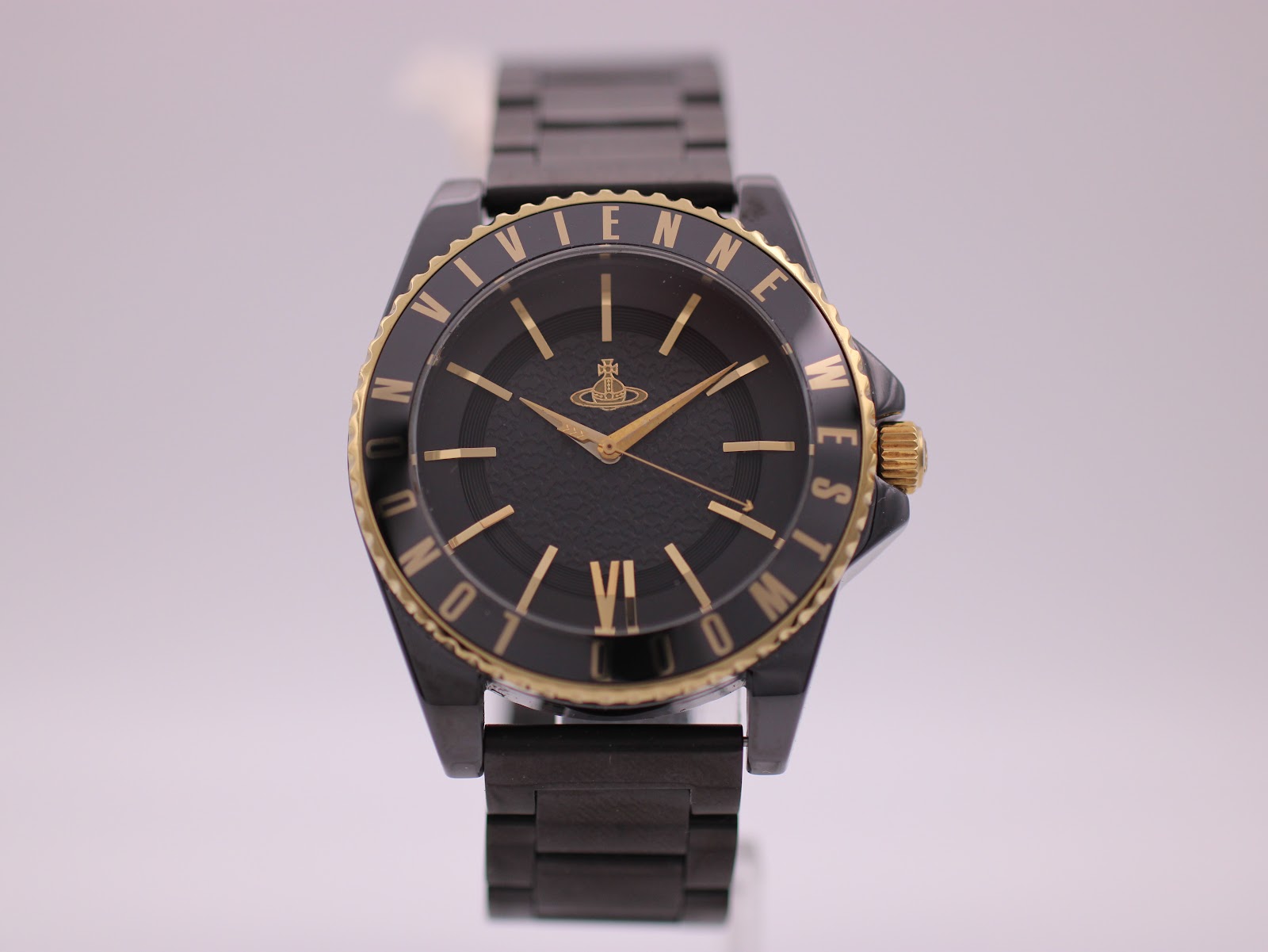 Front view of the Vivienne Westwood VV048GDBK watch with black ceramic case and bracelet, gold-tone bezel and crown.