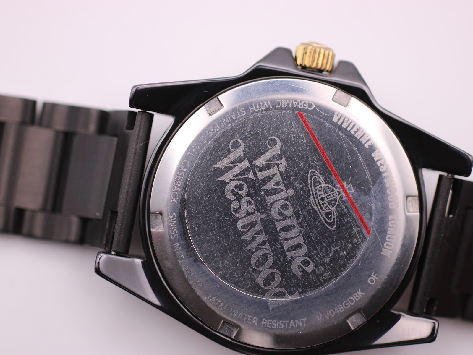 Close-up of the stainless steel caseback showing Vivienne Westwood branding, model number VV048GDBK, and 3ATM water resistance.