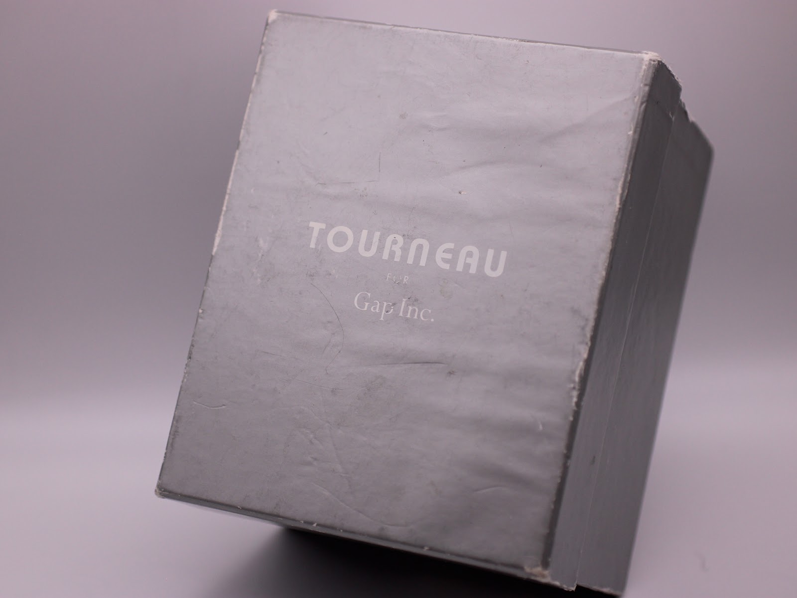 Original grey cardboard outer box with 'Tourneau for Gap Inc.' branding printed on the lid.