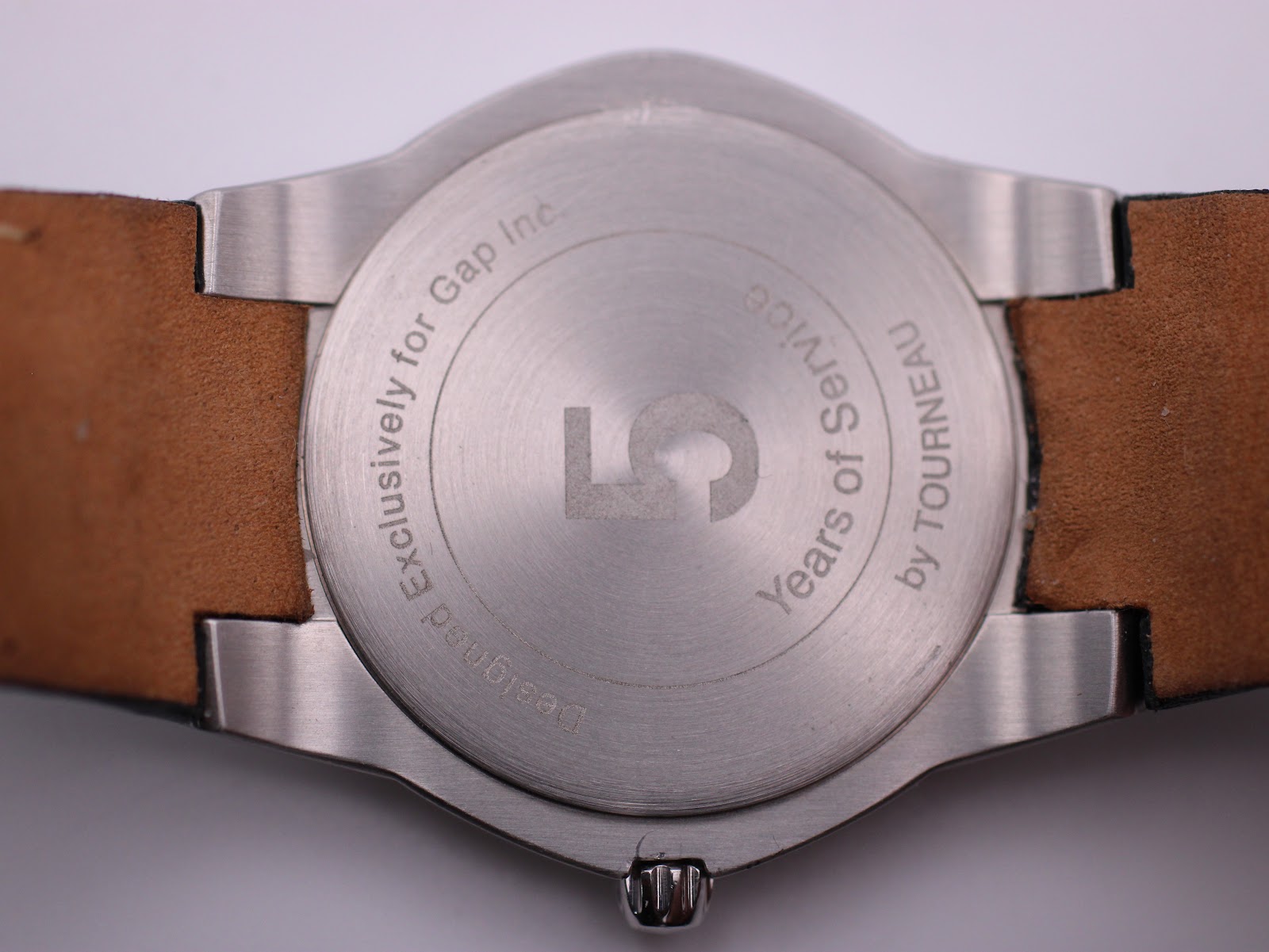 Detailed close-up of the watch's case back, engraved with 'Exclusively for Gap Inc.' and '5 Years of Service by Tourneau'.