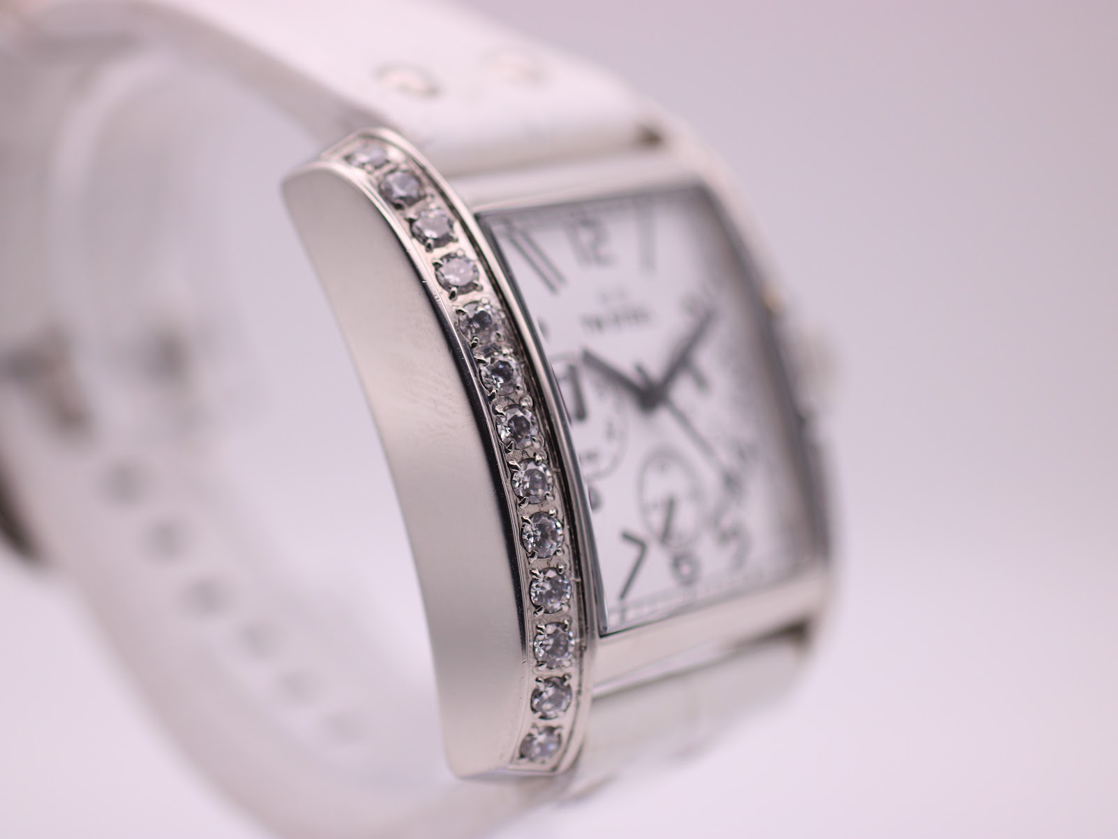 Angled side view highlighting the row of brilliant-cut crystals along the side of the polished case.