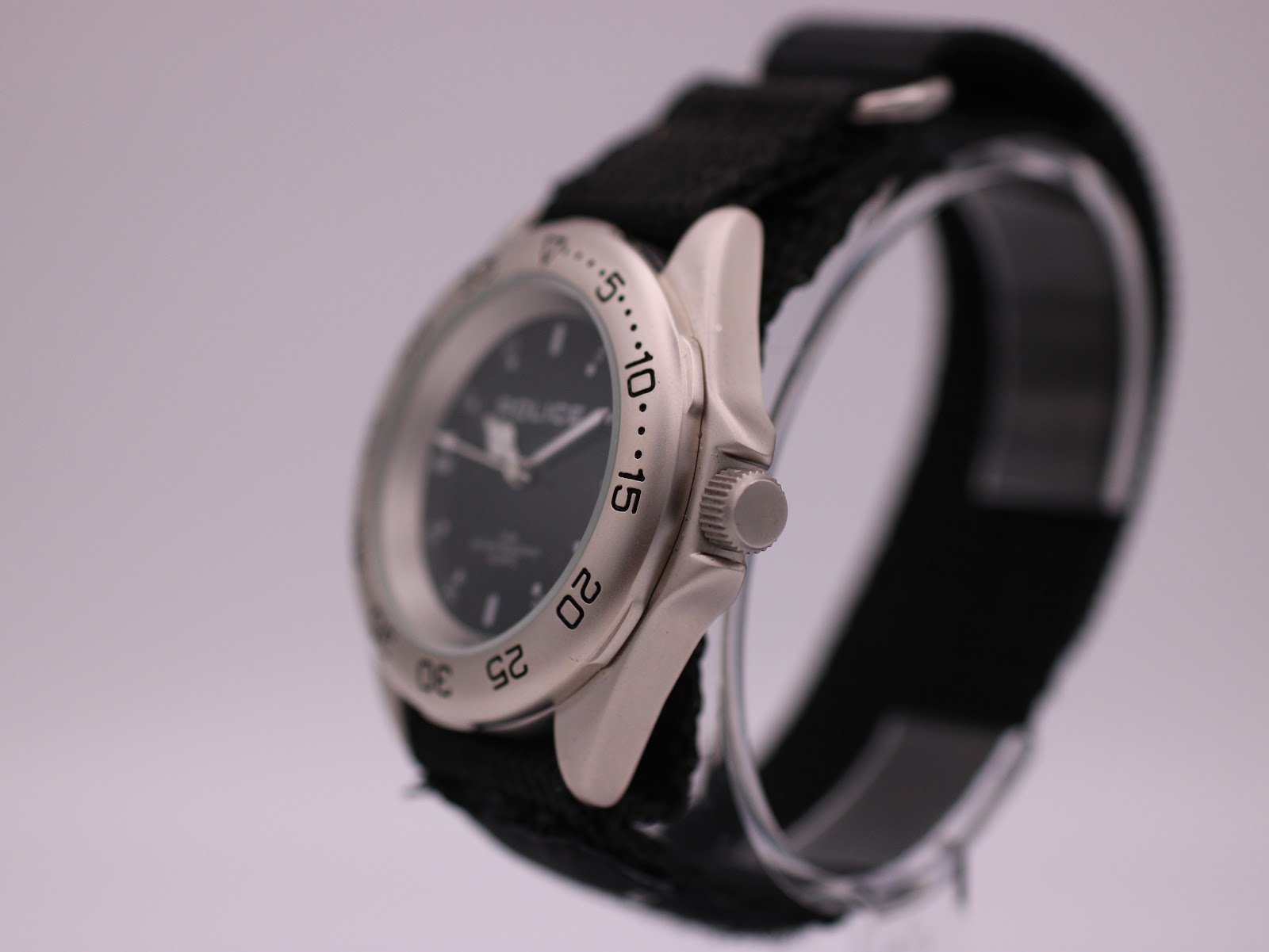 Angled side view of the Police watch, showing the brushed silver-tone case profile and the crown.