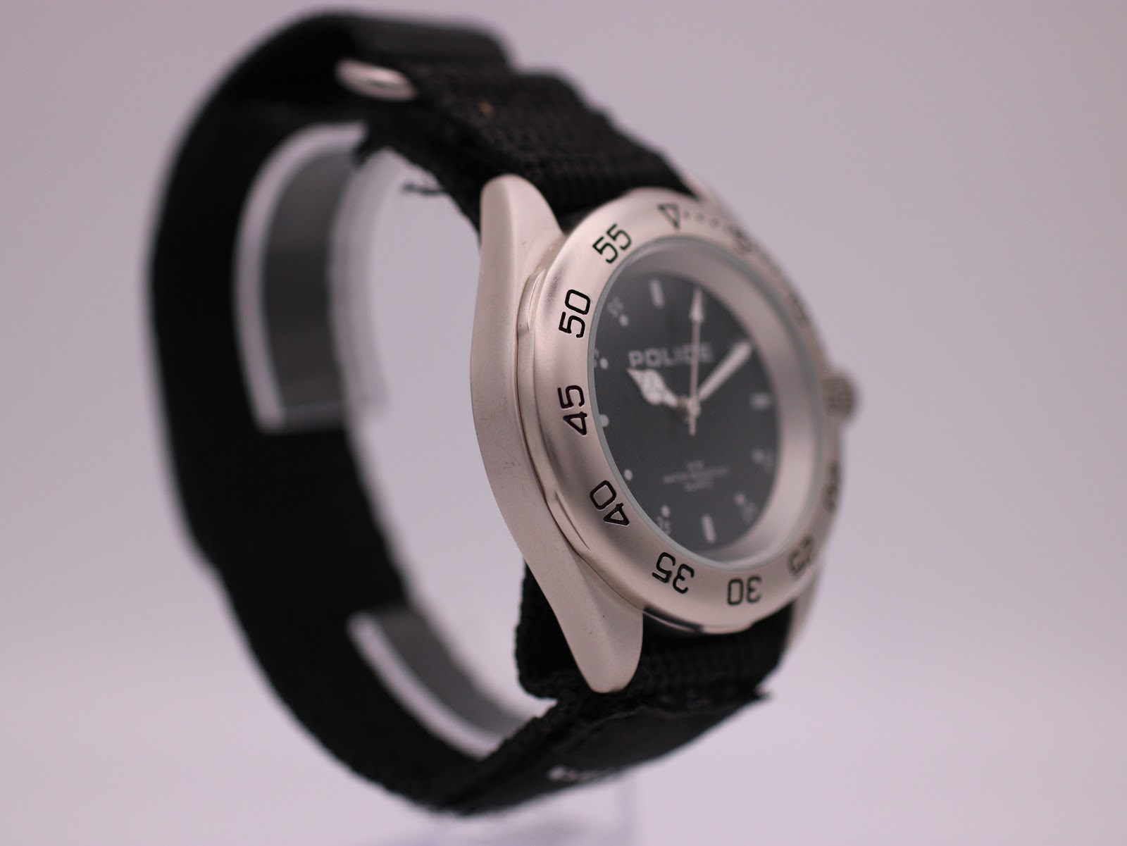 Another angled side view of the Police watch, highlighting the case shape and the marked rotating bezel.