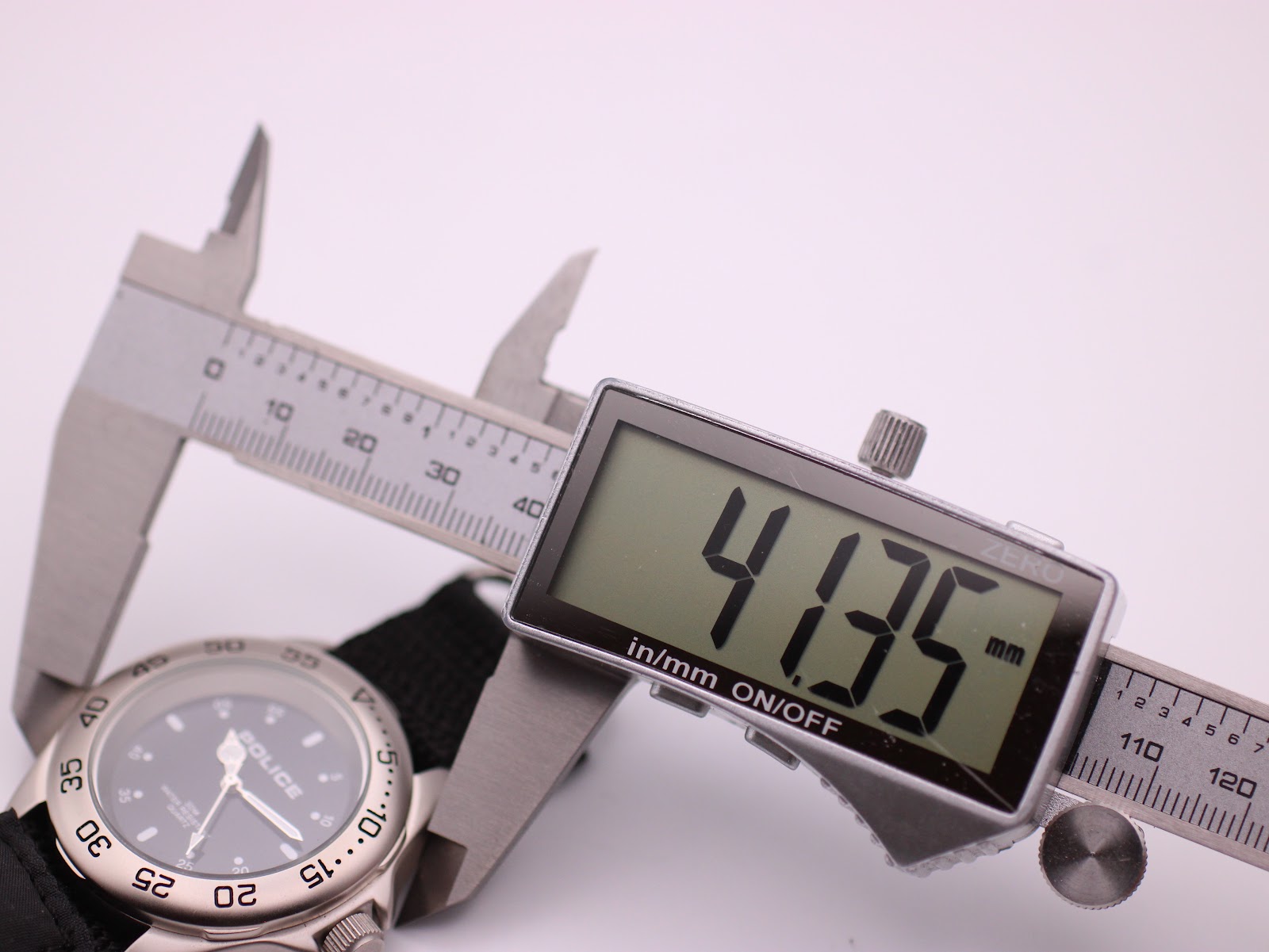 Digital caliper measuring the case diameter of the Police watch, showing a precise reading of 41.35mm.