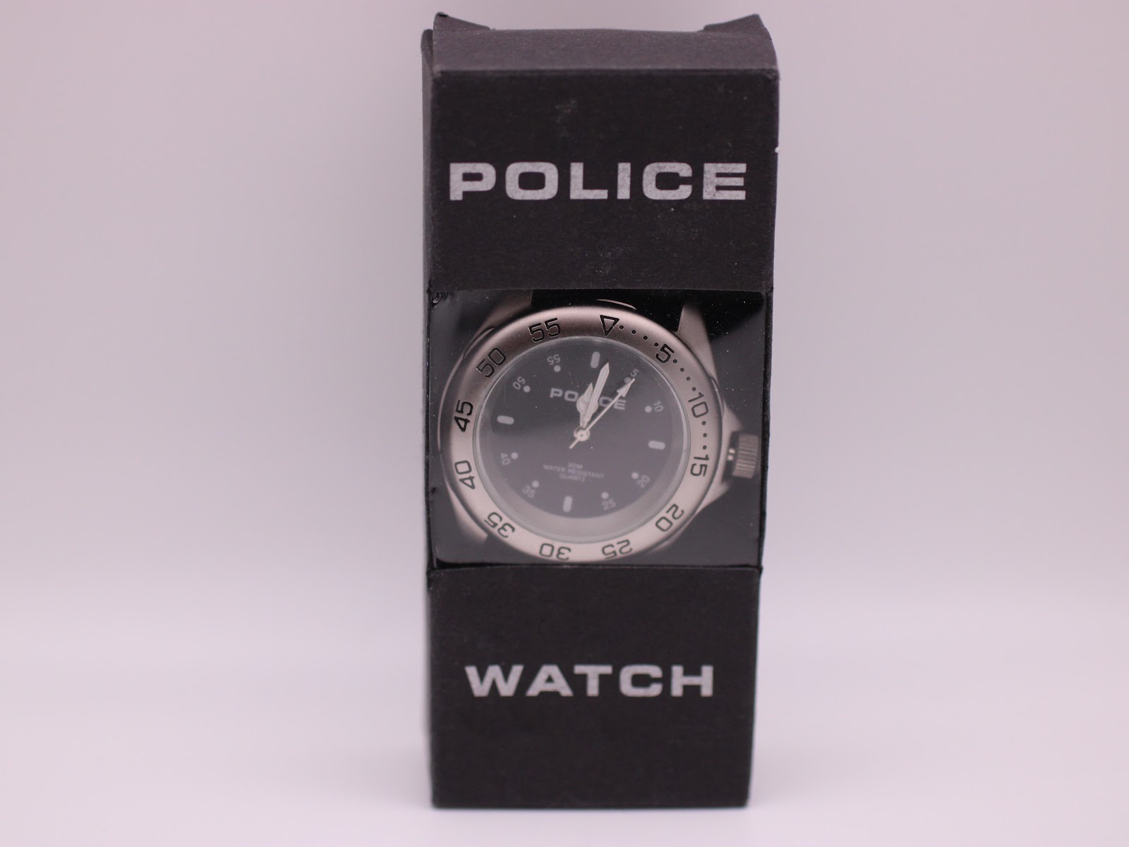 The Police watch displayed upright in its original black cardboard 'POLICE WATCH' retail box with a transparent window.