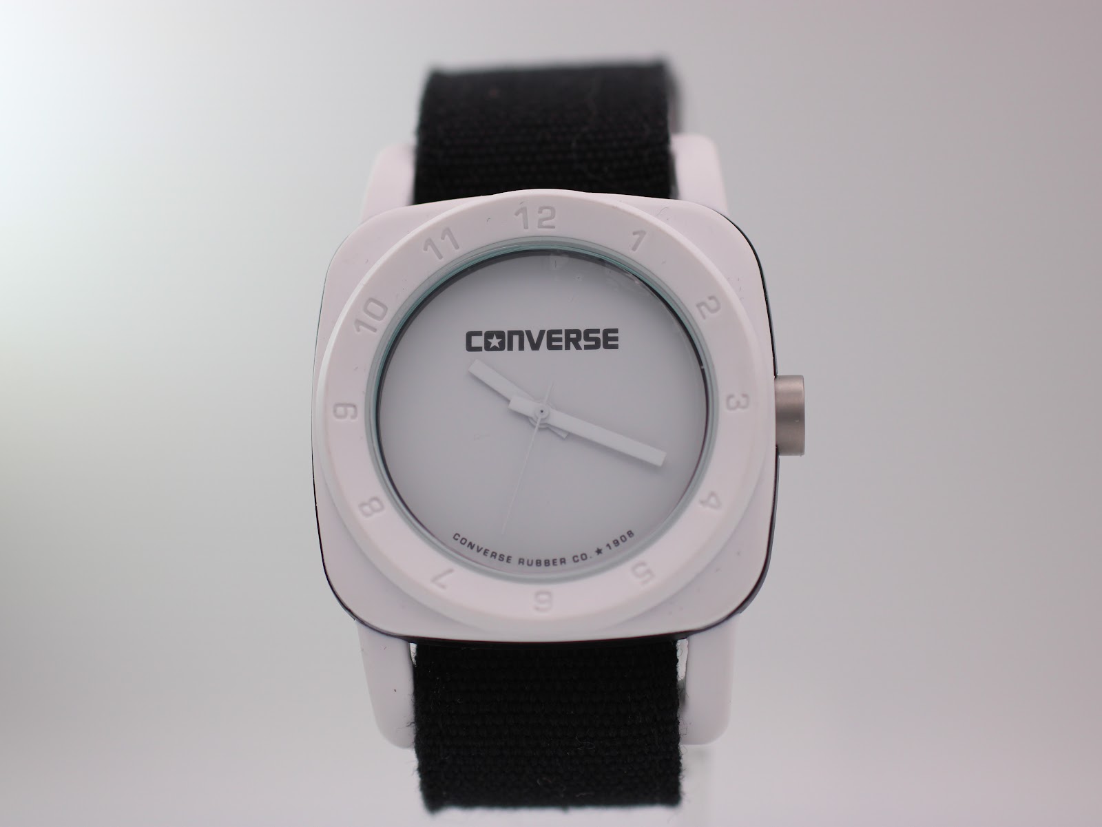 Front view of Converse VRQ22 watch with white square case, white dial, and black NATO strap.