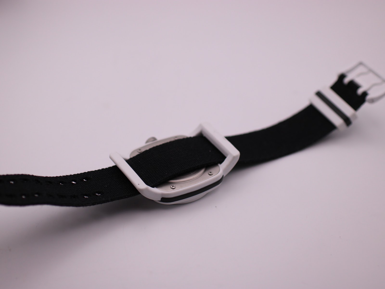 Rear view of the Converse VRQ22 watch, showing the black NATO strap passing under the white case.