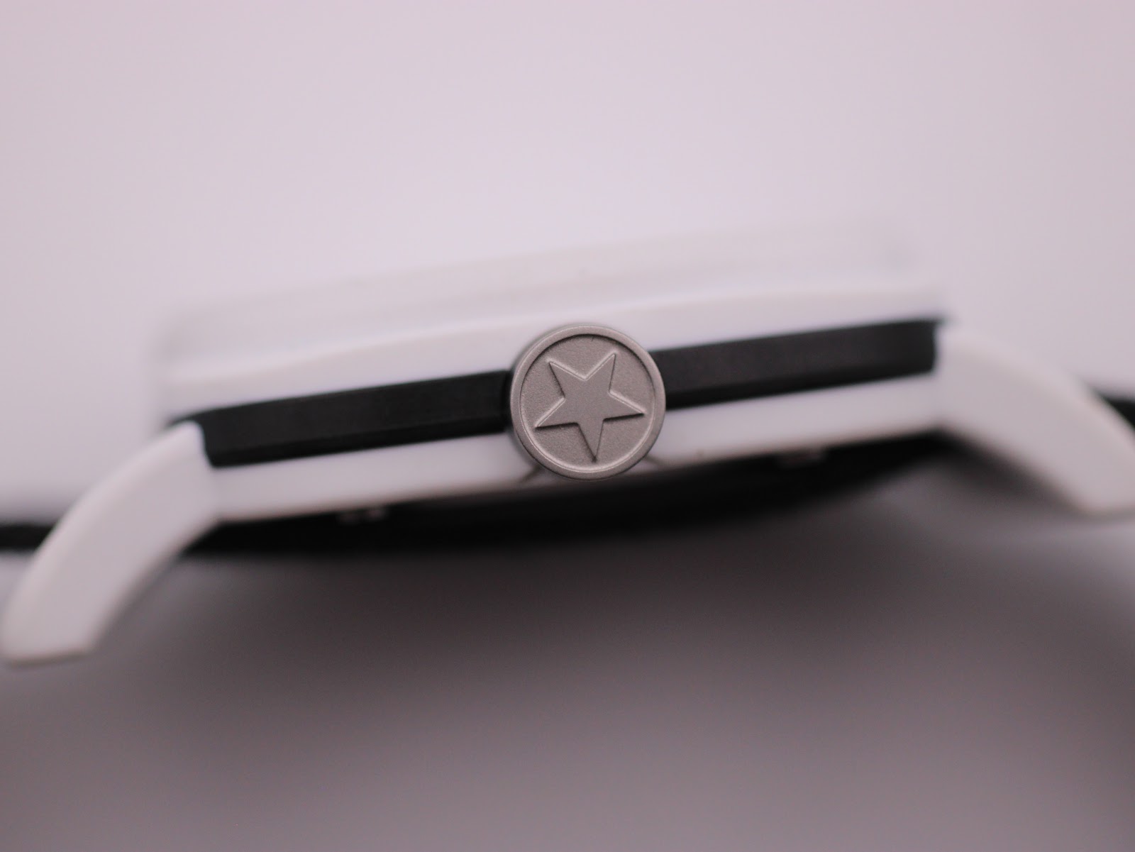 Close-up of the crown with the iconic Converse star logo, on the side of the white and black case.