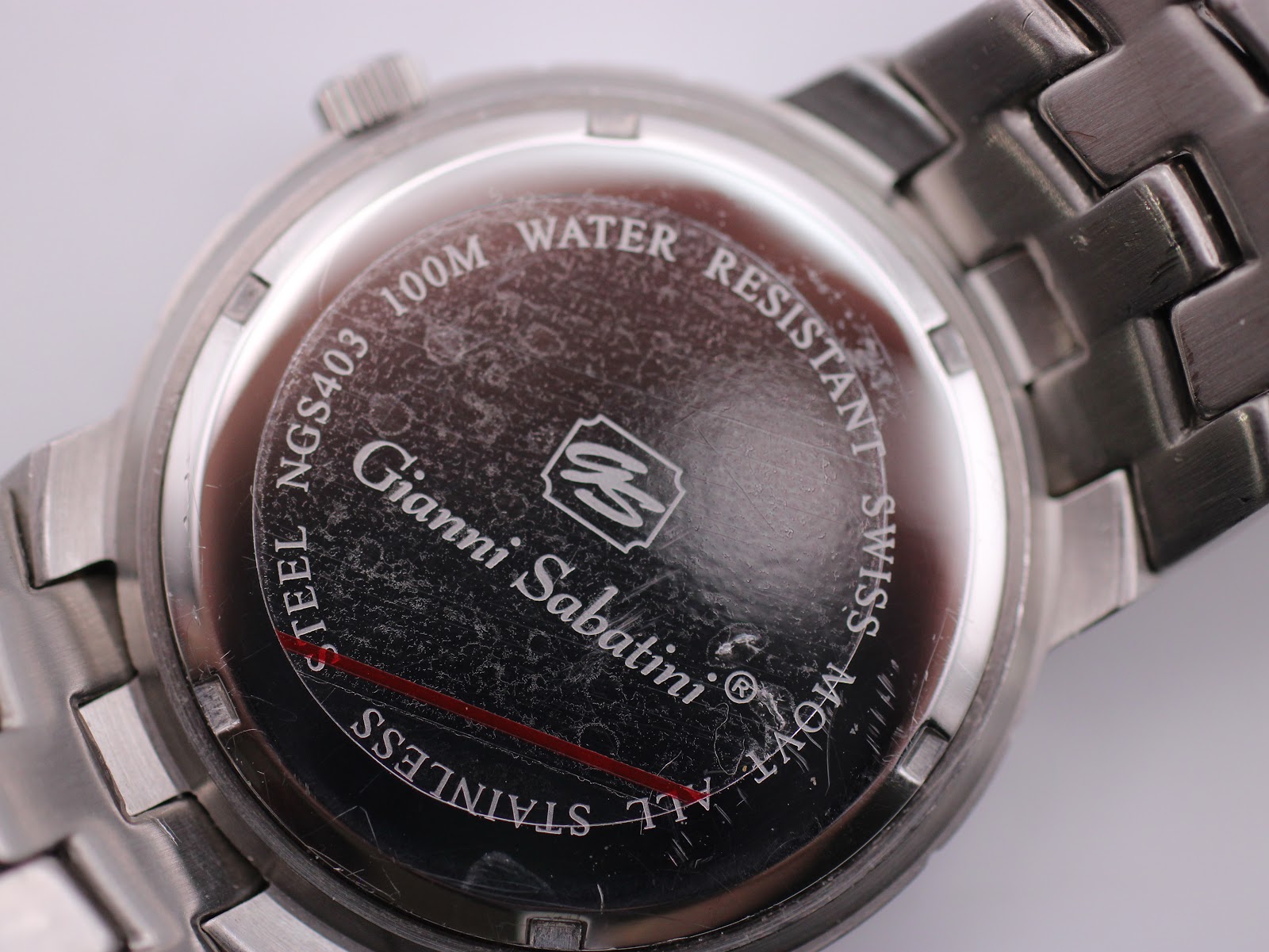 Close-up of the polished stainless steel case back with Gianni Sabatini logo and 100m water resistance text.